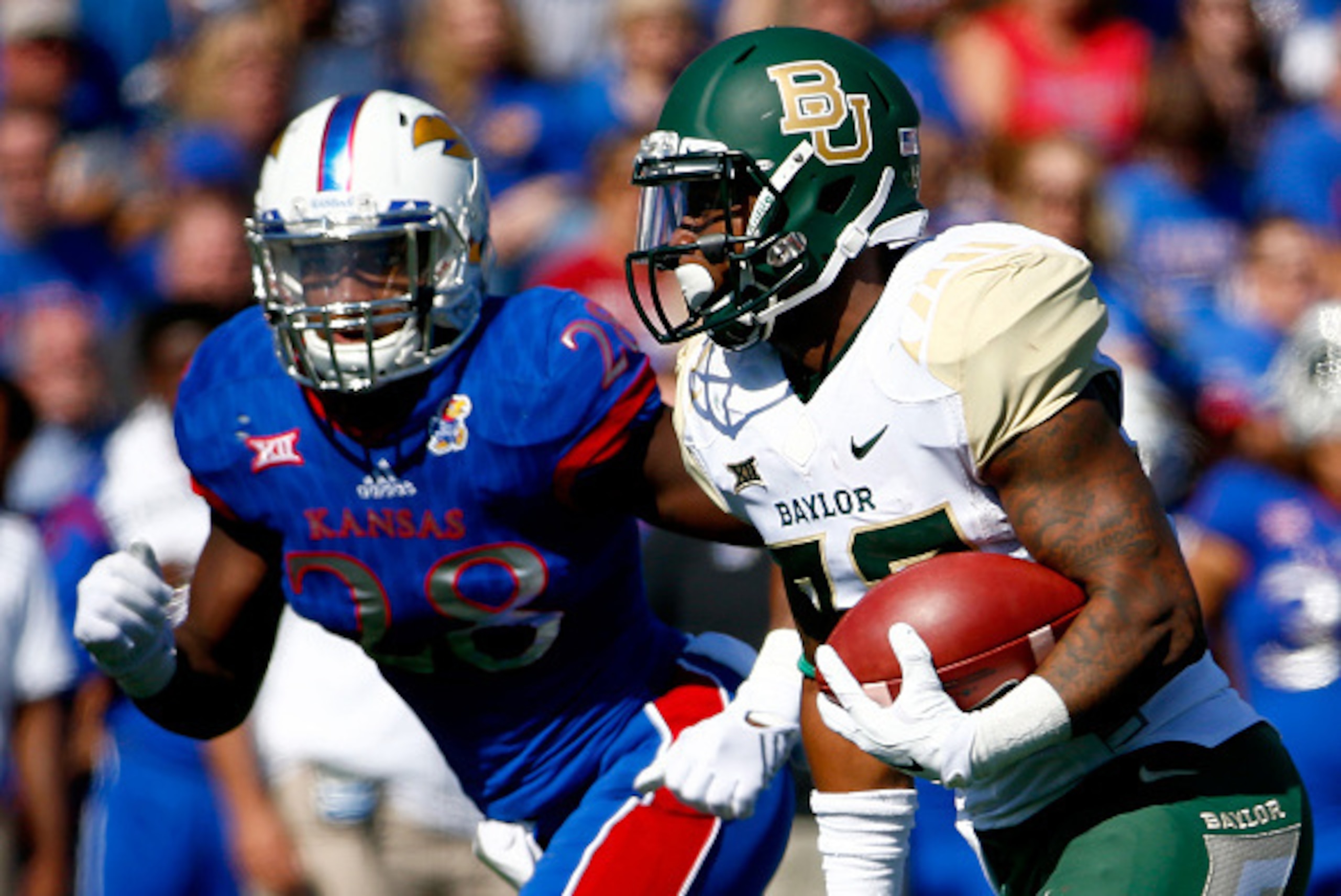 LAWRENCE, KS - OCTOBER 10:  Running back Shock Linwood #32 of the Baylor Bears carries the ball as linebacker Courtney Arnick #28 of the Kansas Jayhawks defends during the game at Memorial Stadium on October 10, 2015 in Lawrence, Kansas.  (Photo by Jamie