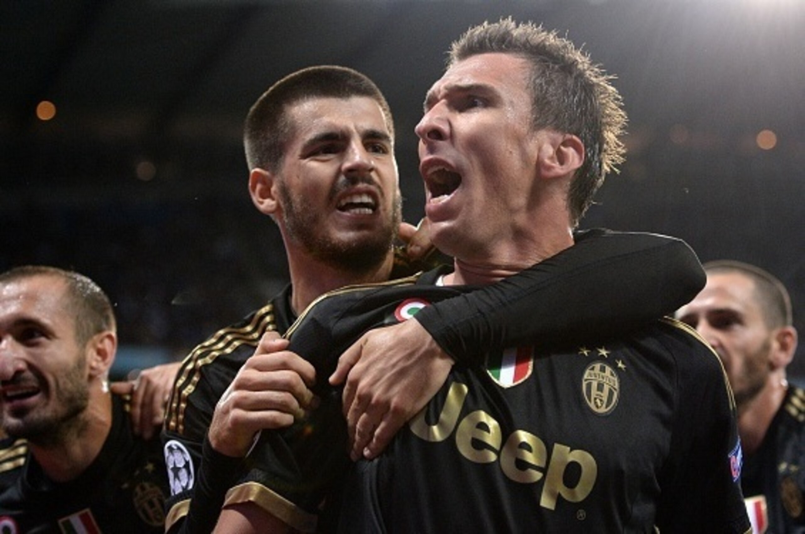 Juventus' forward from Croatia Mario Mandzukic (C) celebrates with Juventus' forward from Spain Alvaro Morata (L) after scoring during a UEFA Champions League group stage football match between Manchester City and Juventus at the Etihad stadium in Manches
