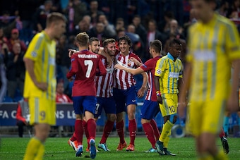 MADRID, SPAIN - OCTOBER 21:  Saul Niguez (2ndR) celebrates scoring their opening goal with teammates Gabi Fernandez (L) and Stefan Savic (R) during the UEFA Champions League Group C match between Club Atletico de Madrid and FC Astana at Vicente Calderon s