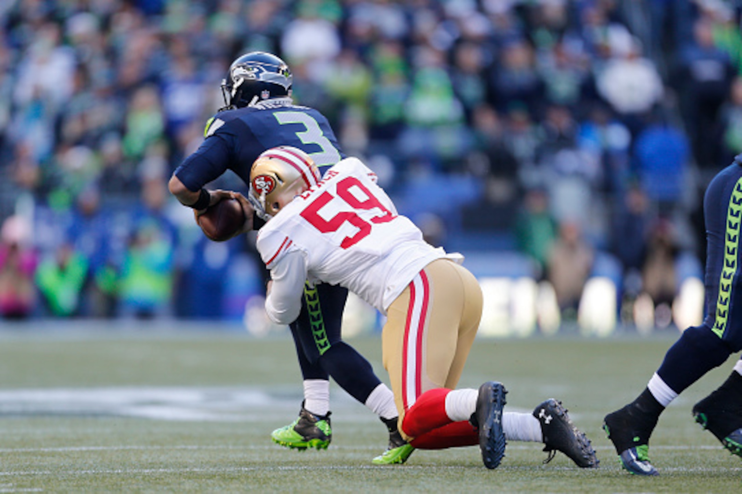 SEATTLE, WA - DECEMBER 14: Aaron Lynch #59 of the San Francisco 49ers pressures Russell Wilson #3 of the Seattle Seahawks during the game at CenturyLink Field on December 14, 2014 in Seattle, Washington. The Seahawks defeated the 49ers 17-7. (Photo by Mic SEATTLE, WA - DECEMBER 14: Aaron Lynch #59 of the San Francisco 49ers pressures Russell Wilson #3 of the Seattle Seahawks during the game at CenturyLink Field on December 14, 2014 in Seattle, Washington. The Seahawks defeated the 49ers 17-7. (Photo by Mic