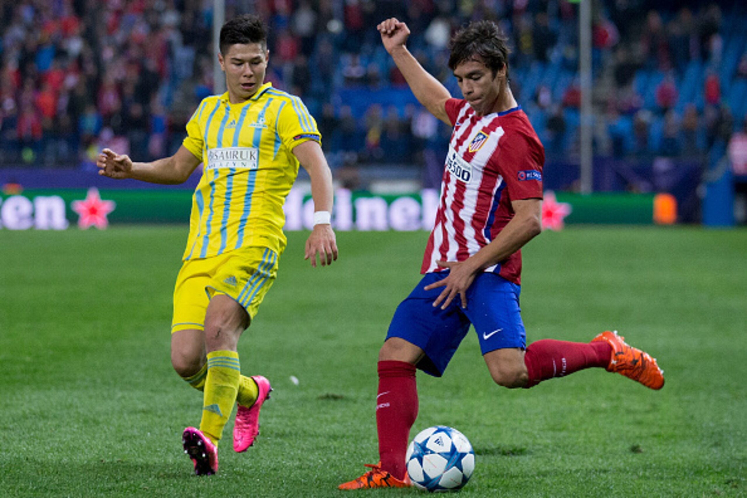 MADRID, SPAIN - OCTOBER 21: Oliver Torres (R) of Atletico de Madrid competes for the ball with Georgi Zhukov (L) of FC Astana during the UEFA Champions League Group C match between Club Atletico de Madrid and FC Astana at Vicente Calderon stadium on Octob