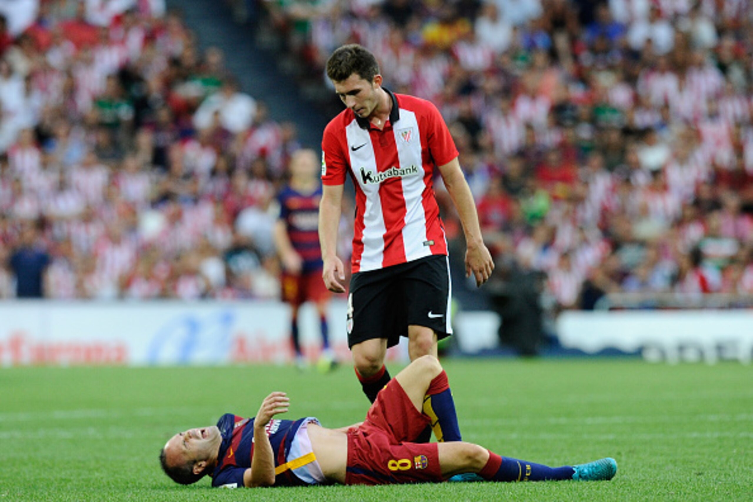 BILBAO, SPAIN - AUGUST 23:   Aymeric Laporte of Club Athletic checks up on Andres Iniesta of FC Barcelona after Iniesta took a knock during the La Liga match between Athletic Club and FC Barcelona at San Mames Stadium on August 23, 2015 in Bilbao, Spain. 