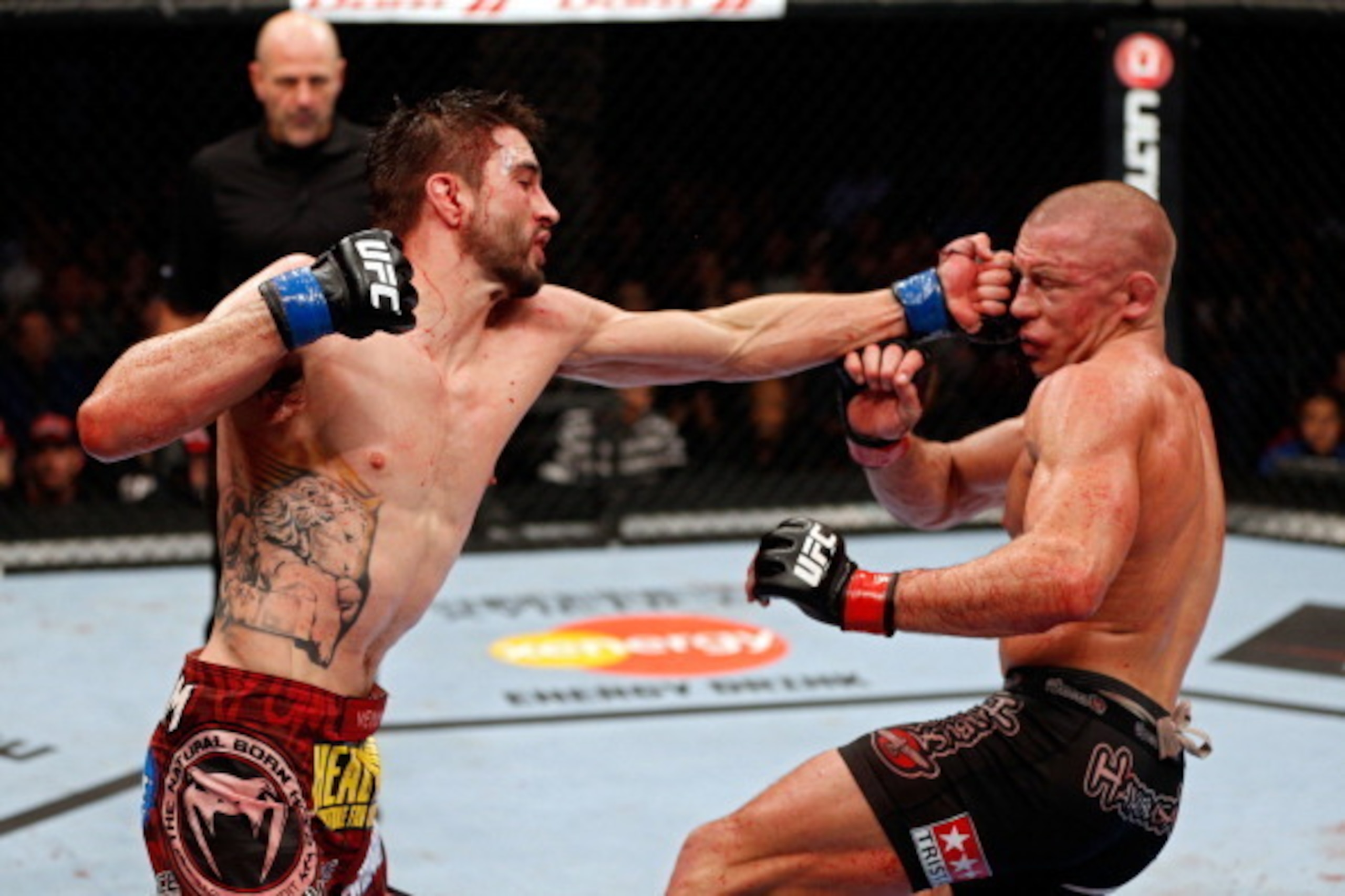 MONTREAL, QC - NOVEMBER 17:  Carlos Condit (L) lands a punch against Georges St-Pierre in their welterweight title bout during UFC 154 on November 17, 2012  at the Bell Centre in Montreal, Canada.  (Photo by Josh Hedges/Zuffa LLC/Zuffa LLC via Getty Image