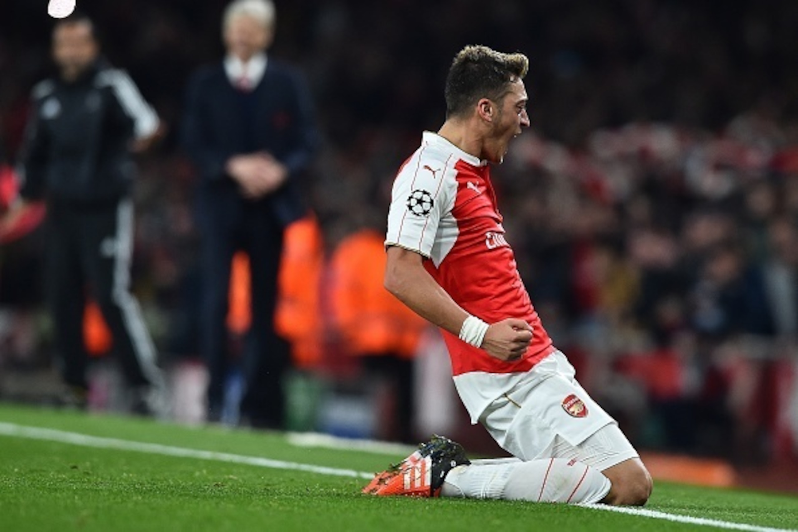 Arsenal's German midfielder Mesut Ozil (R) celebrates scoring his team's second goal during the UEFA Champions League football match between Arsenal and Bayern Munich at the Emirates Stadium in London, on October 20, 2015.  Arsenal won the match 2-0.  AFP