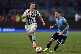 Lazio's midfielder Lucas Biglia (R) and Juventus defender Stephan Lichtsteiner vie for the ball during the Italian Super Cup final football match between Juventus and Lazio in Shanghai on August 8, 2015. AFP PHOTO / JOHANNES EISELE        (Photo credit sh