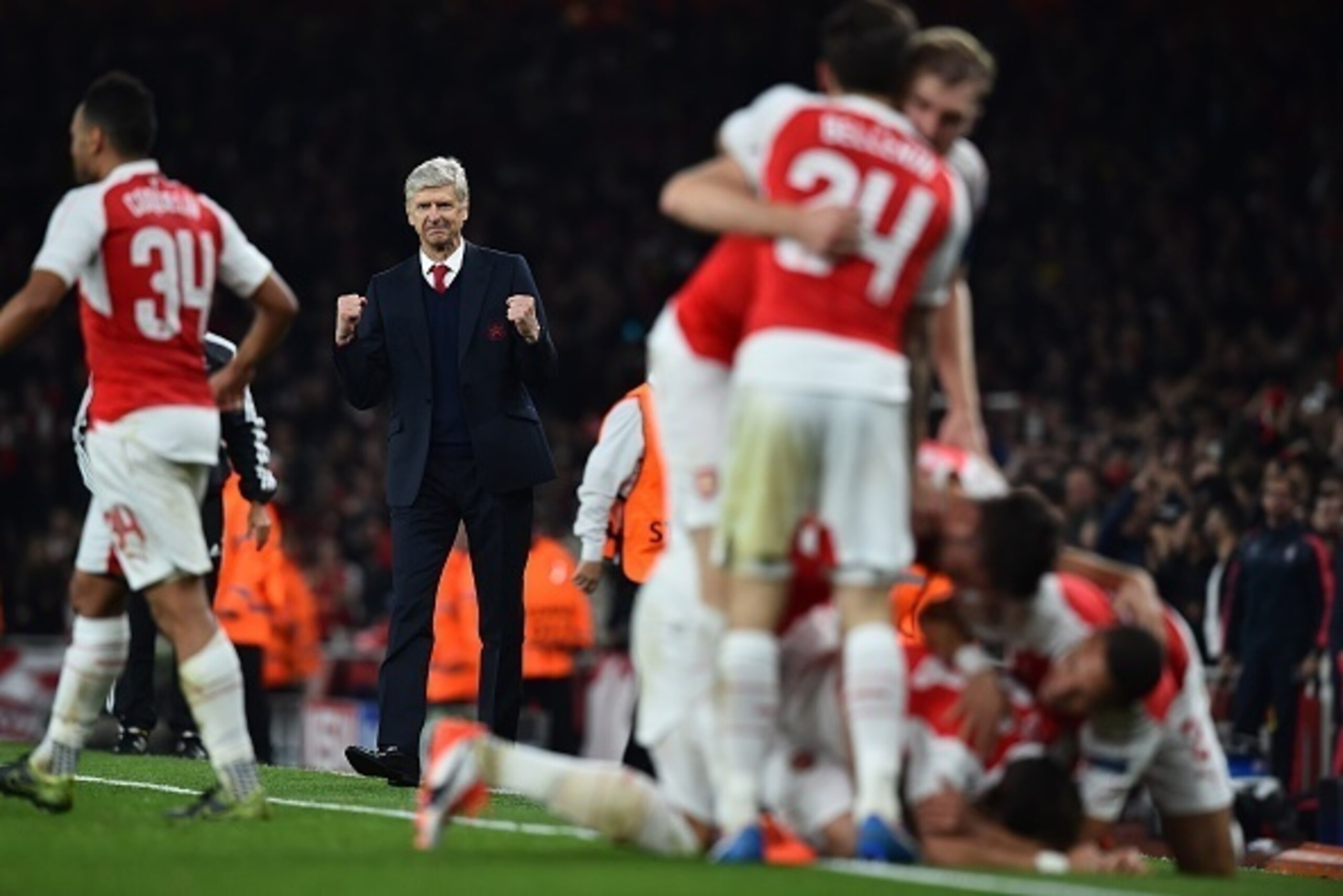 Arsenal's French manager Arsene Wenger (2L) reacts as his players celebrate Arsenal's German midfielder Mesut Ozil goal during the UEFA Champions League football match between Arsenal and Bayern Munich at the Emirates Stadium in London, on October 20, 201