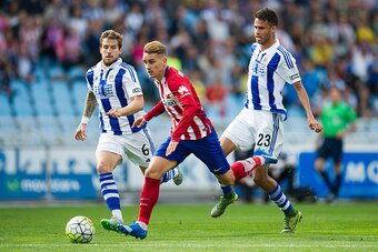 SAN SEBASTIAN, SPAIN - OCTOBER 18:  Antoine Griezmann of Atletico de Madrid duels for the ball with Inigo Martinez of Real Sociedad during the La Liga match between Real Sociedad de Futbol and Atletico de Madrid at Estadio Anoeta on October 18, 2015 in Sa