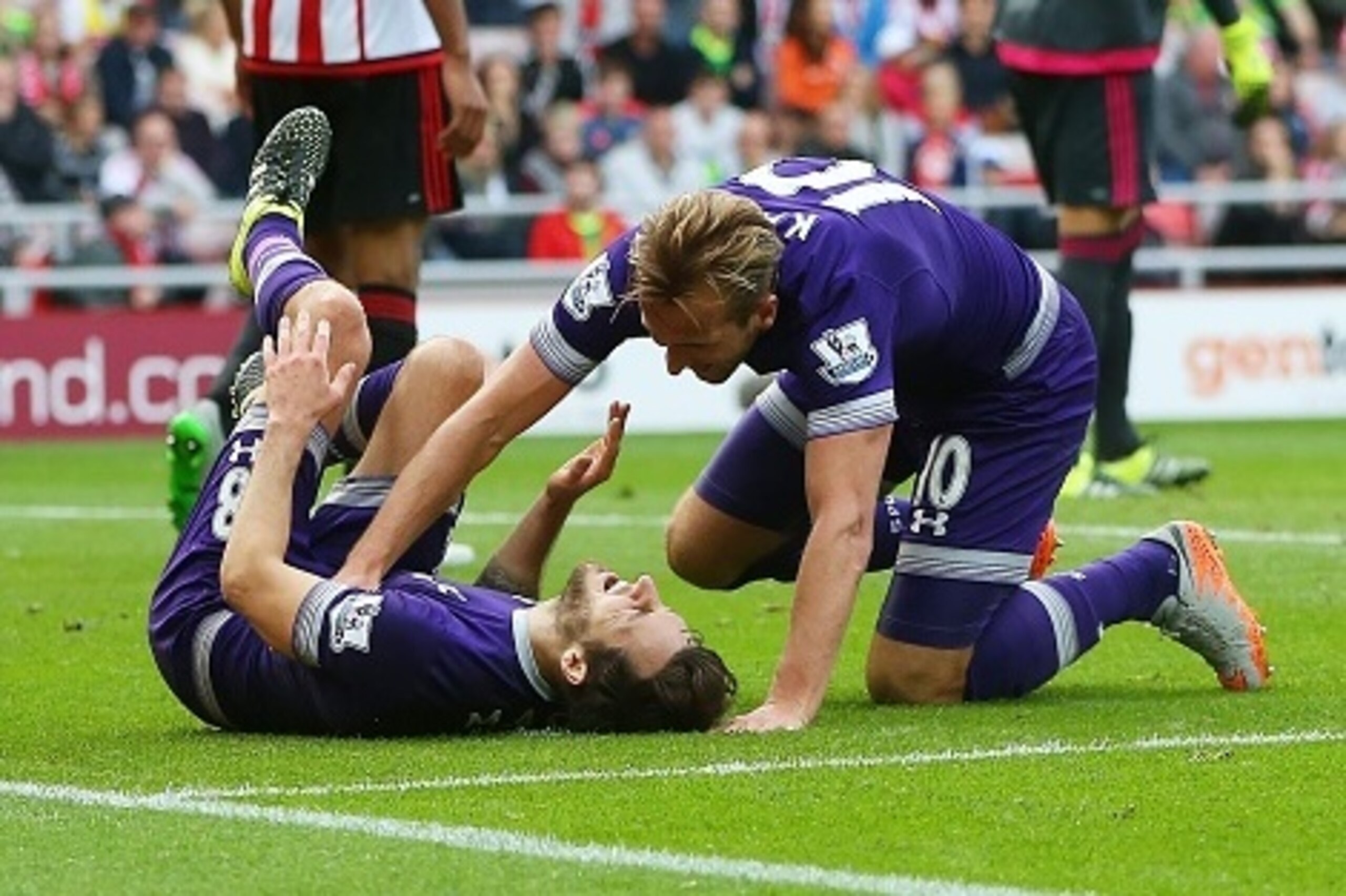 Tottenham Hotspur's English striker Harry Kane (R) attends to Tottenham Hotspur's English midfielder Ryan Mason, as he lies injured after scoring the opening goal of the English Premier League football match between Sunderland and Tottenham Hotspur at the