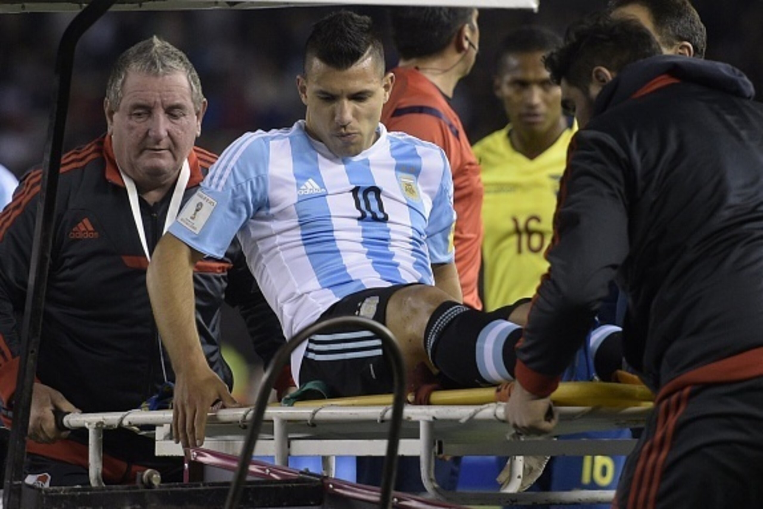 Argentina's forward Sergio Aguero is assisted by medical staff during their Russia 2018 FIFA World Cup qualifiers match against Ecuador, at the Nacional stadium in Santiago de Chile, on October 8, 2015.   AFP PHOTO / JUAN MABROMATA        (Photo credit sh