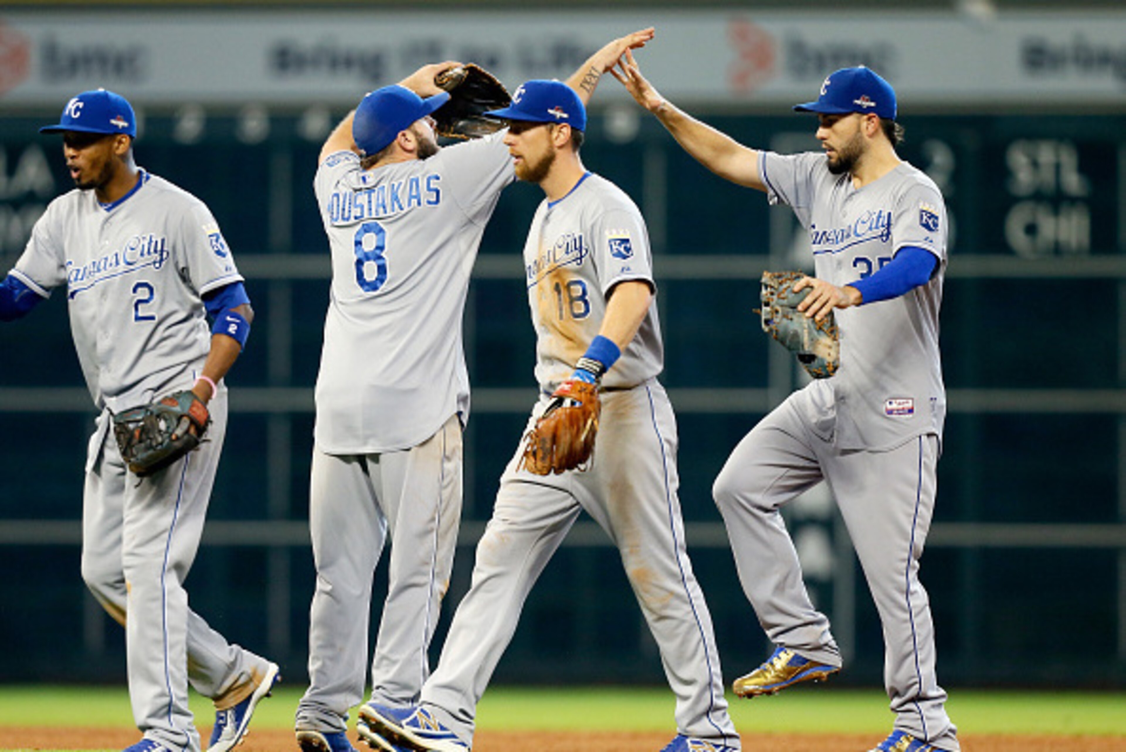 HOUSTON, TX - OCTOBER 12: Alcides Escobar #2, Mike Moustakas #8, Ben Zobrist #18 and Eric Hosmer #35 of the Kansas City Royals celebrate after defeating the Houston Astros during game four of the American League Divison Series at Minute Maid Park on Octob