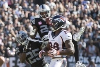 October 11, 2015; Oakland, CA, USA; Oakland Raiders free safety Charles Woodson (24) intercepts the football intended for Denver Broncos wide receiver Demaryius Thomas (88) during the third quarter at O.co Coliseum. The Raiders defeated the Broncos 16-10.