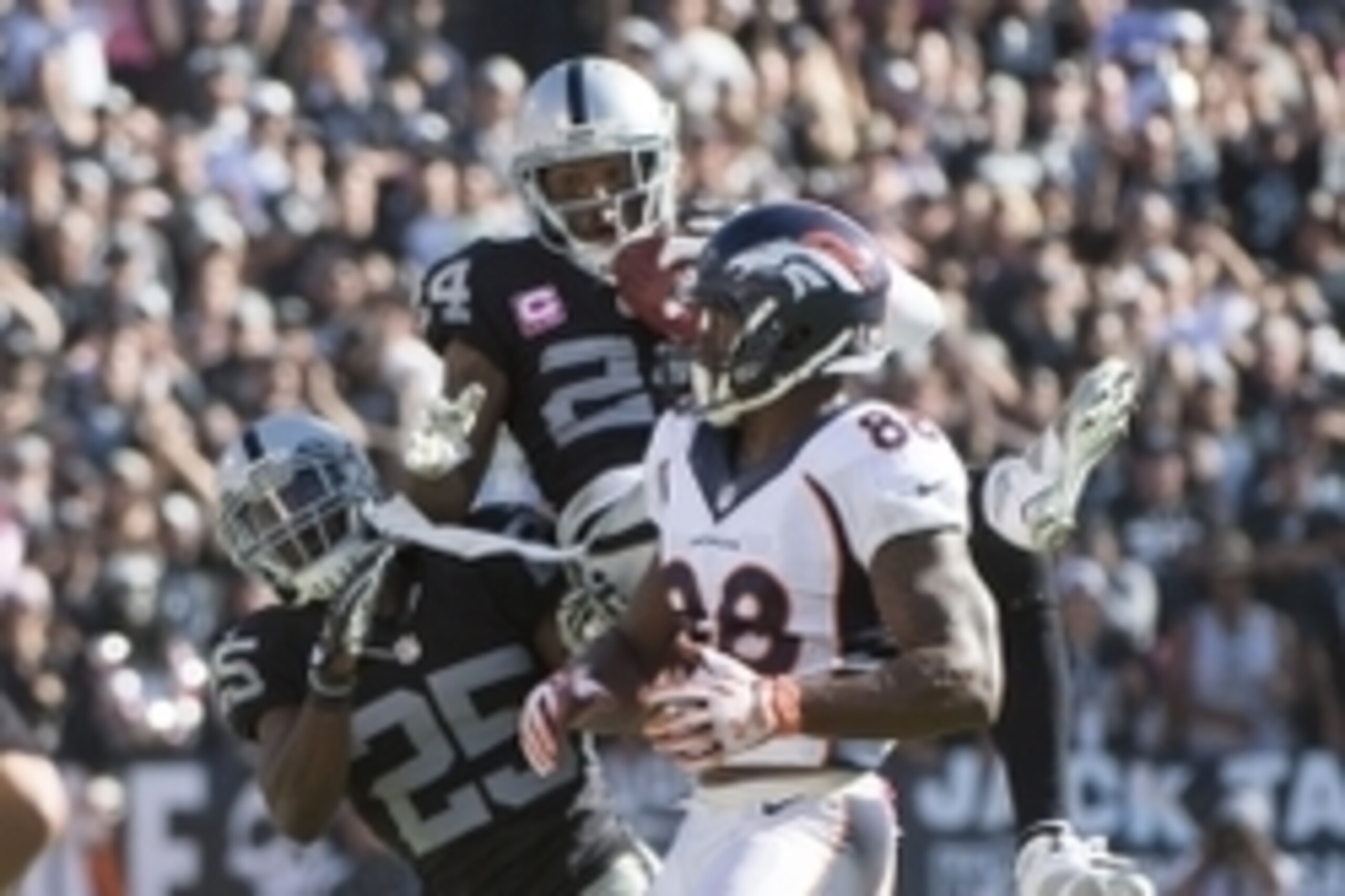 October 11, 2015; Oakland, CA, USA; Oakland Raiders free safety Charles Woodson (24) intercepts the football intended for Denver Broncos wide receiver Demaryius Thomas (88) during the third quarter at O.co Coliseum. The Raiders defeated the Broncos 16-10.