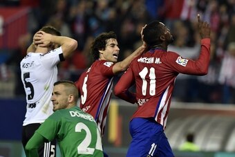 Atletico Madrid's Colombian forward Jackson Martinez (R) celebrates a goal with Atletico Madrid's Portuguese midfielder Tiago (2nd L) next to Valencia's goalkeeper Jaume Domenech (2nd L) and Valencia's German defender Shkodran Mustafi (L) during the Spani