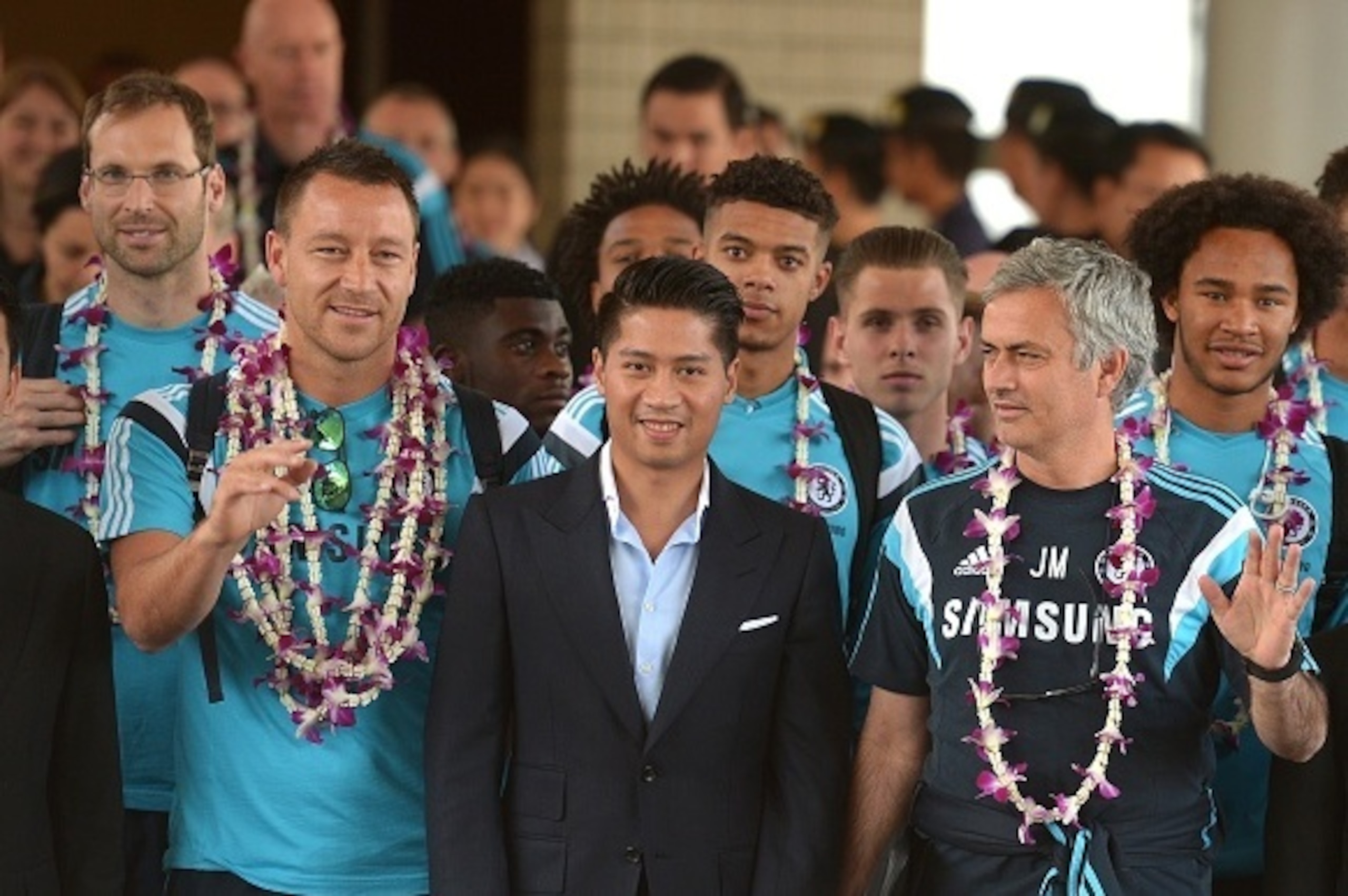 Chelsea manager Jose Mourinho (R) and his players gesture to the media upon their arrival at Don Muang Airport in Bangkok on May 28, 2015. The Blues will meet Thailand's All Stars at the 49,000-capacity Rajamangala Stadium in Bangkok for a special match o