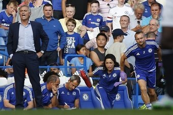 Chelsea doctor (2R) Eva Carneiro and head physio Jon Fearn (R) leave the bench to treat Chelsea's Belgian midfielder Eden Hazard late in the game as Chelsea's Portuguese manager Jose Mourinho (L) gestures during the English Premier League football match b