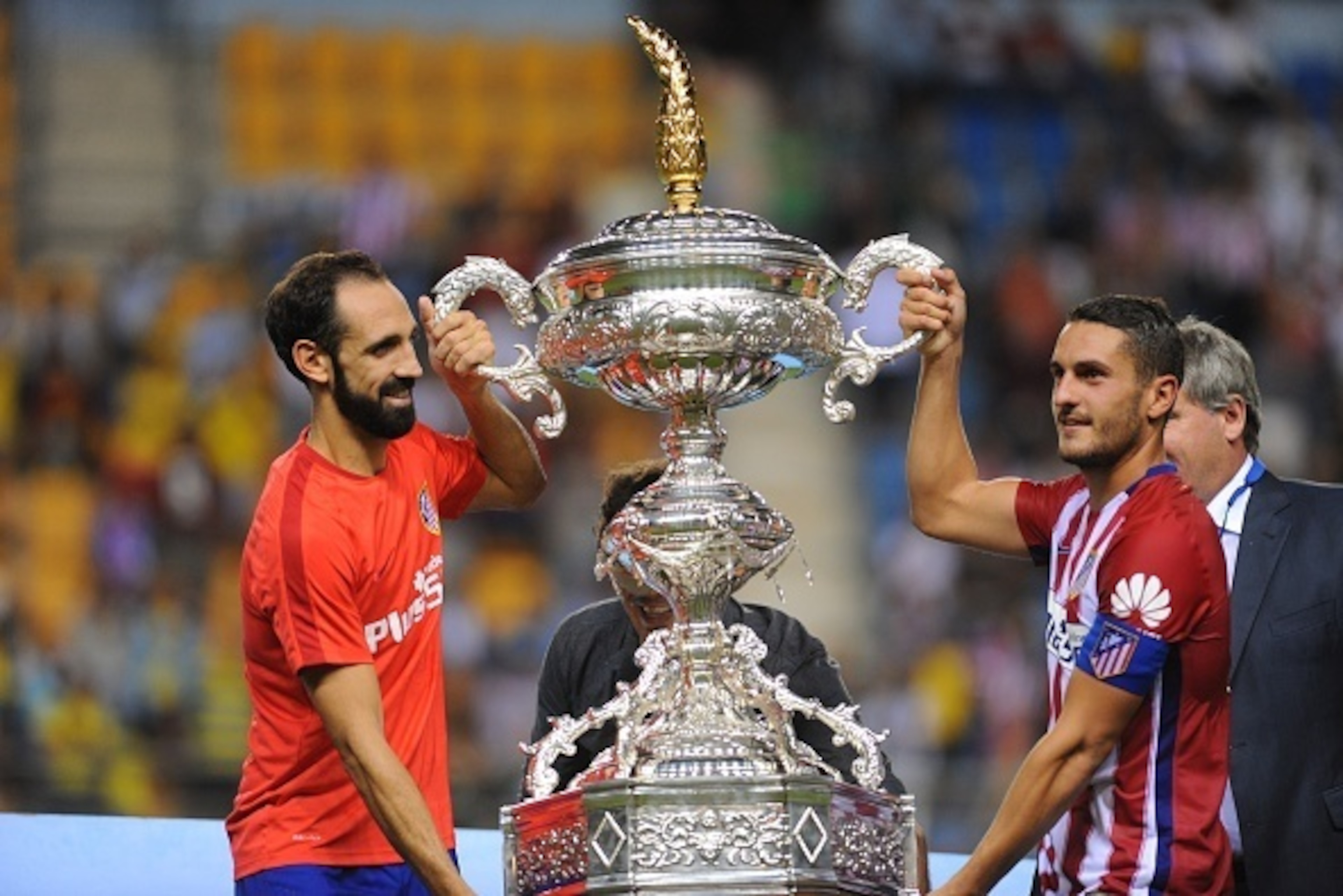 Atletico Madrid's defender Juanfran (L) and Atletico Madrid's midfielder Koke (R) pose with the trophy after winning the Trofeo Carranza football match Atletico de Madrid vs Betis at the Ramon de Carranaza stadium in Cadiz on August 15, 2015. Atletico de 