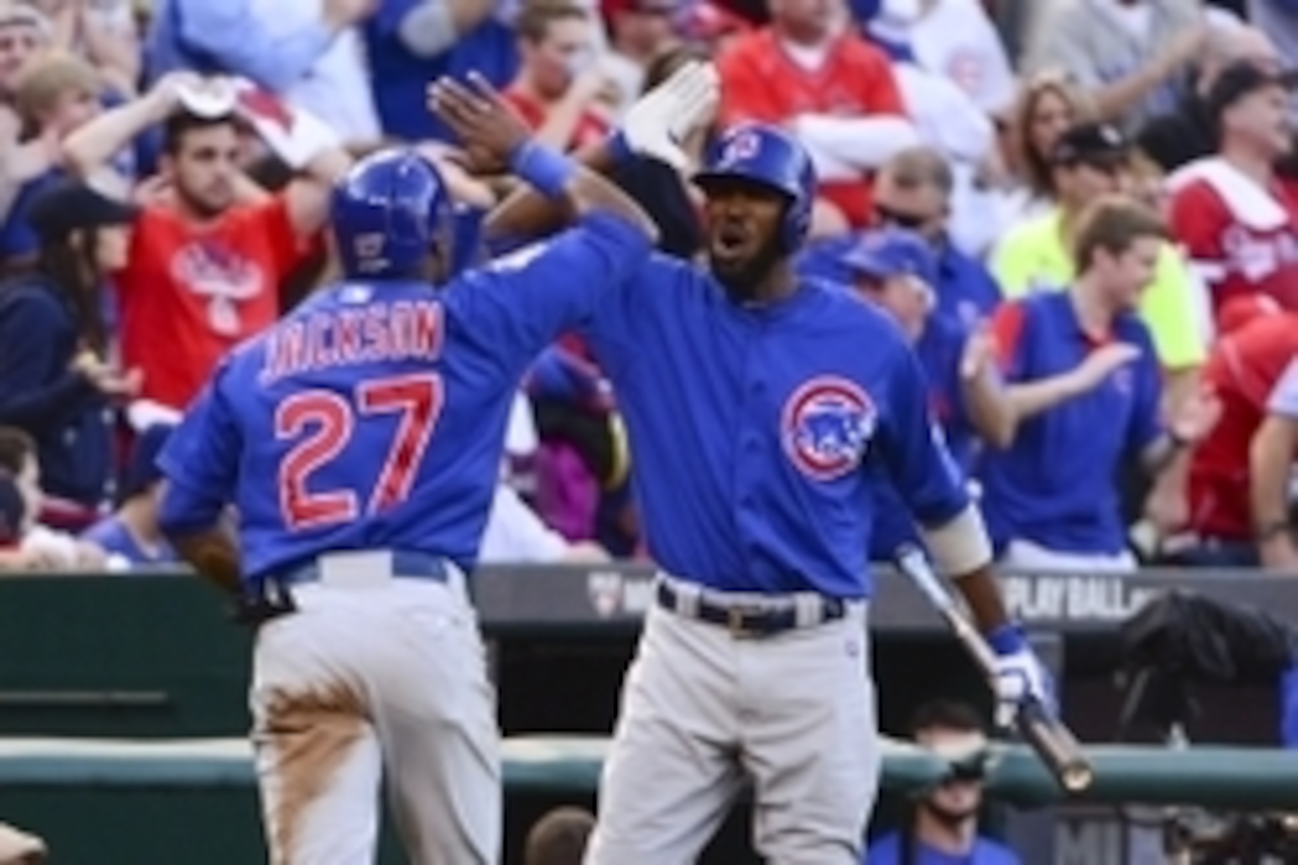 Oct 10, 2015; St. Louis, MO, USA; Chicago Cubs left fielder Austin Jackson (27) is congratulated by center fielder Dexter Fowler (right) after scoring on a sacrifice bunt by starting pitcher Kyle Hendricks (not pictured) during the second inning in game t