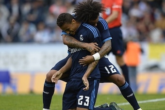 Real Madrid's Brazilian defender Danilo (L) is congratulated by Brazilian defender Marcelo after scoring a goal during the Spanish league football match Celta Vigo vs Real Madrid CF at the Balaidos stadium in Vigo on October 24, 2015.  AFP PHOTO / MIGUEL 