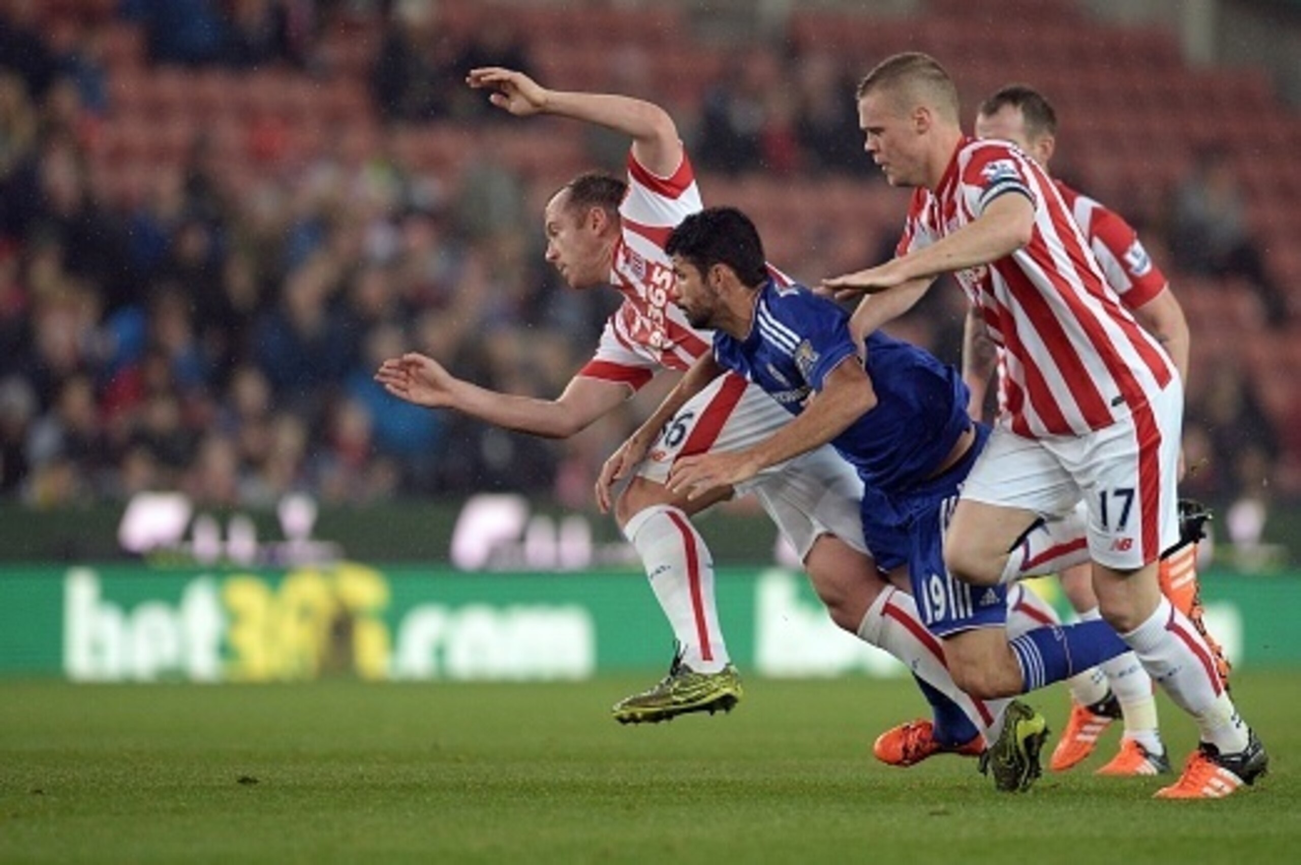 Chelsea's Brazilian-born Spanish striker Diego Costa (C) vies against Stoke City's Scottish midfielder Charlie Adam (L) and Stoke City's English defender Ryan Shawcross (R) during the English League Cup fourth round football match between Stoke City and C