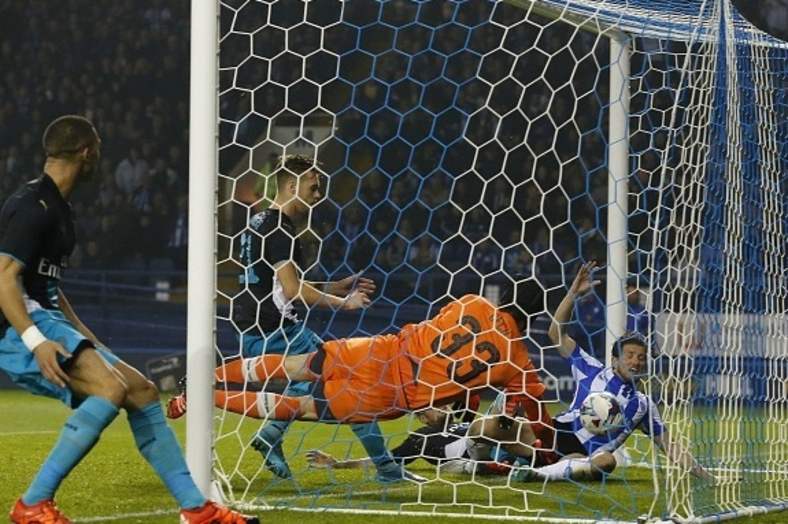 Sheffield Wednesday's English defender Sam Hutchinson (R) beats Arsenal's Czech goalkeeper Petr Cech (C) to score the team's third goal during the English League Cup fourth round football match between Sheffield Wednesday and Arsenal at The Hillsborough S