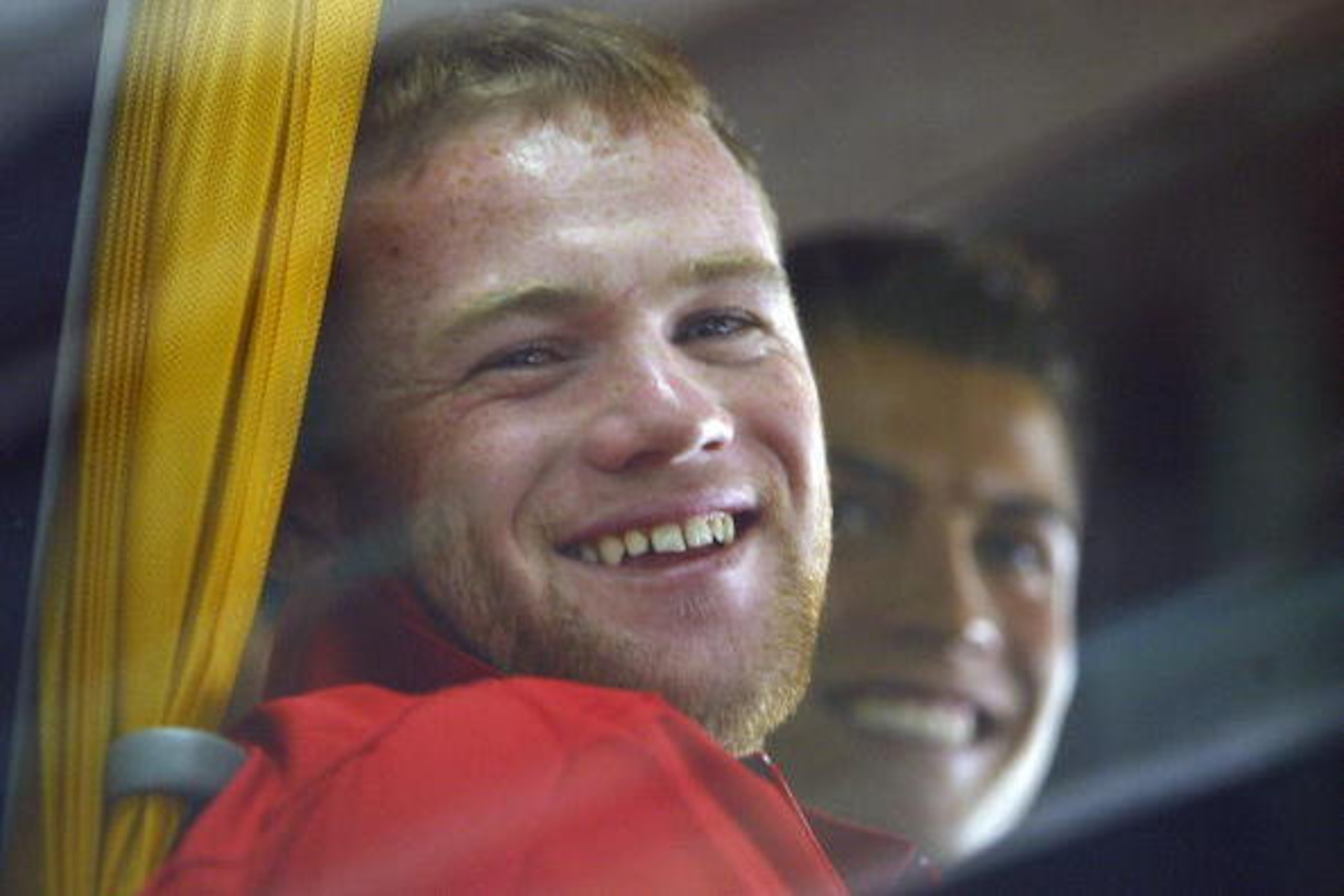 Lisbon, PORTUGAL:  Machester United's players British Wayne Rooney (L) and Portuguese Cristiano Ronaldo (R) smile as they seat inside a bus outside the Portela airport in Lisbon, 25 September 2006. Manchester will face SL Benfica the 26 September 2006 on 