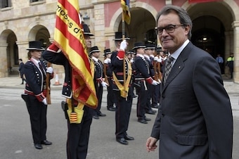 Catalan regional police (Mossos d'Esquadra) present arms as Catalan regional president Artur Mas (R) inspects the troops after the constitutive session of the Catalan regional Parliament on October 26, 2015 in Barcelona. AFP PHOTO / LLUIS GENE        (Pho
