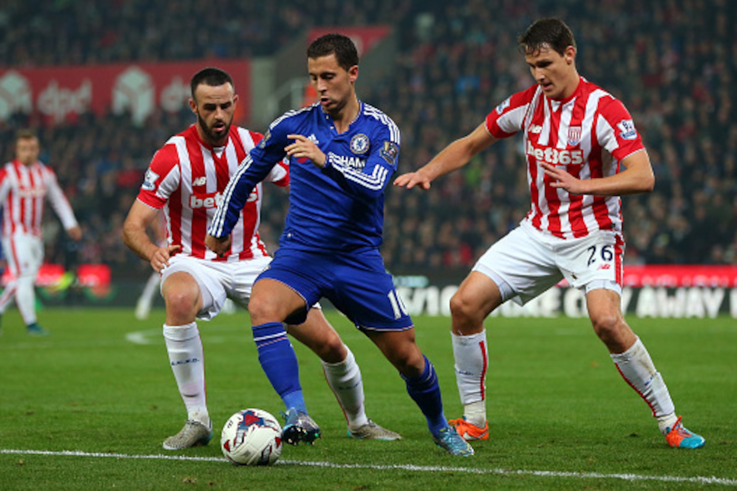 STOKE ON TRENT, ENGLAND - OCTOBER 27:  Eden Hazard of Chelsea in action with Marc Wilson and Philipp Wollscheid of Stoke City during the Capital One Cup Fourth Round match between Stoke City and Chelsea at Britannia Stadium on October 27, 2015 in Stoke on