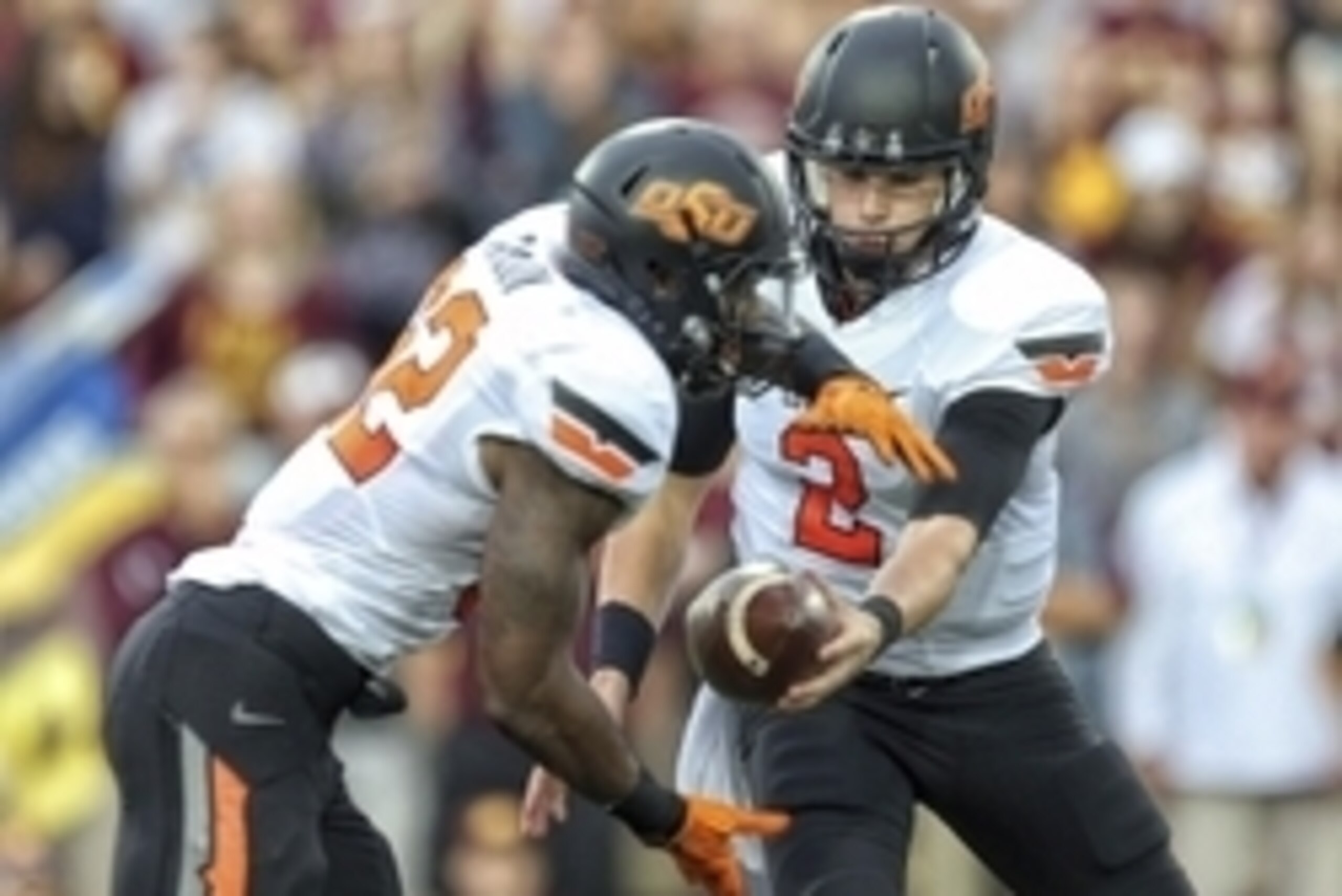 Sep 3, 2015; Mount Pleasant, MI, USA;  Oklahoma State Cowboys quarterback Mason Rudolph (2) attempts to hand the ball off to running back Todd Mays (22) during the 1st quarter against the Central Michigan Chippewas at Kelly/Shorts Stadium. Mandatory Credi