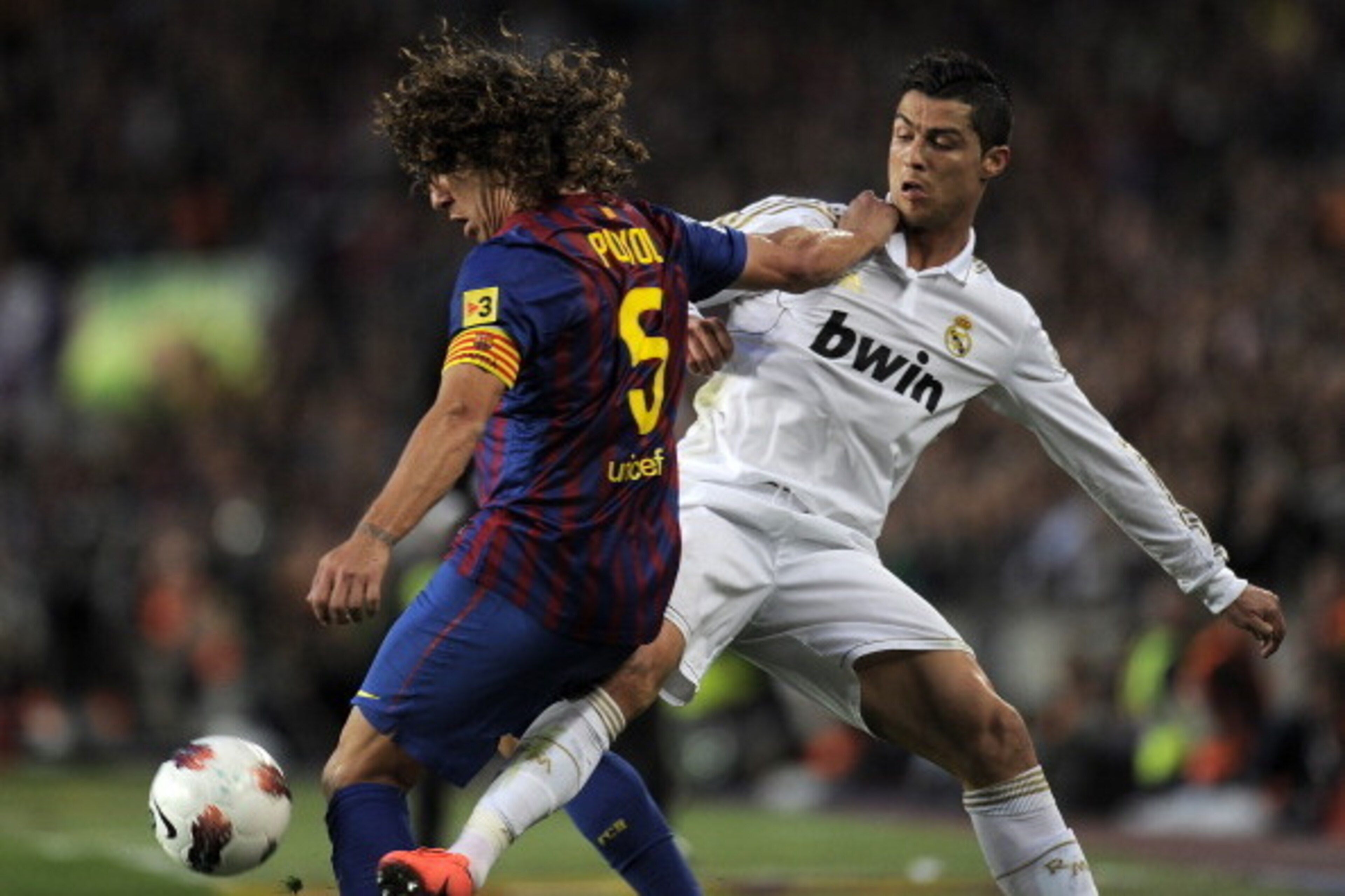 Barcelona's captain Carles Puyol (L) vies with Real Madrid's Portuguese forward Cristiano Ronaldo during the Spanish League 'El clasico' football match Barcelona vs Real Madrid at the Camp Nou stadium in Barcelona on April 21, 2012. AFP PHOTO / LLUIS GENE Barcelona's captain Carles Puyol (L) vies with Real Madrid's Portuguese forward Cristiano Ronaldo during the Spanish League 'El clasico' football match Barcelona vs Real Madrid at the Camp Nou stadium in Barcelona on April 21, 2012. AFP PHOTO / LLUIS GENE