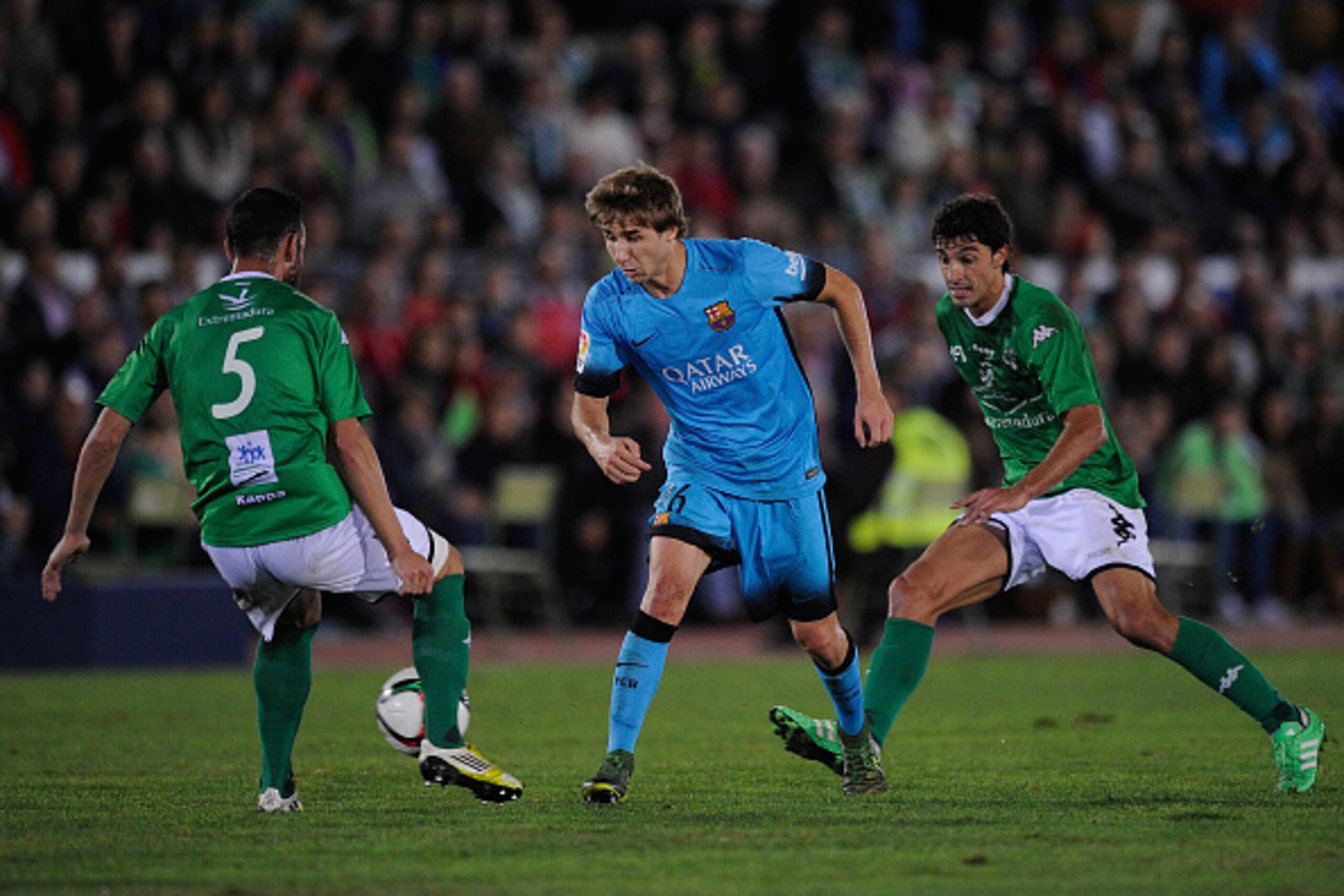 VILLANUEVA DE LA SERENA, SPAIN - OCTOBER 28:  Sergi Samper of FC Barcelona flicks the ball past Javi Sanchez of FC Villanovense during the Copa del Rey Last of 16 First Leg match between C.F. Villanovense and F.C. Barcelona at estadio Romero Cuerda on Oct