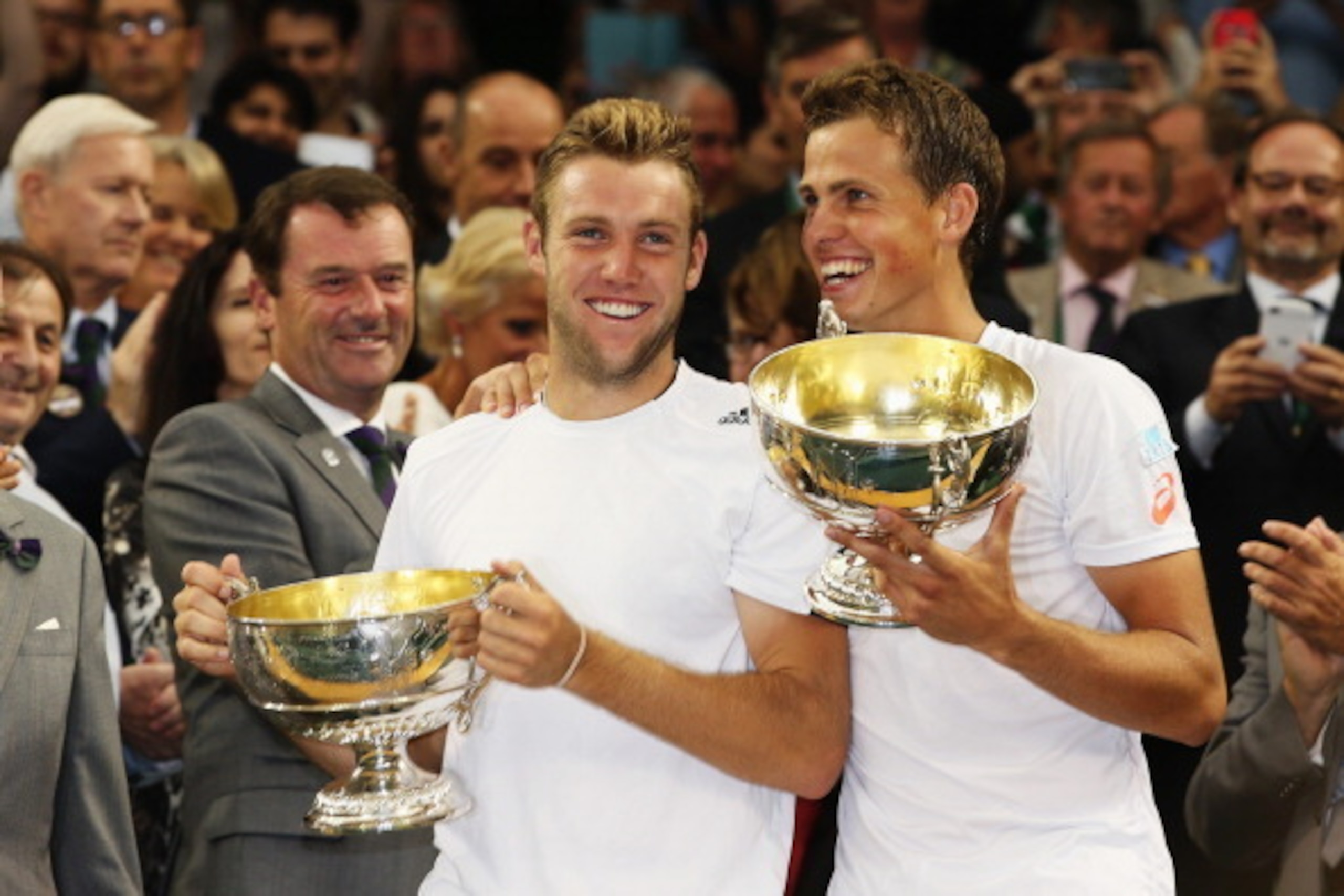 LONDON, ENGLAND - JULY 05:  Jack Sock of the United States (l) and Vasek Pospisil of Canada celebrate with the winners trophies after winning the Gentlemen's Doubles Final against Bob Bryan and Mike Bryan of the United States on day twelve of the Wimbledo