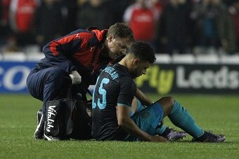 Arsenal's English striker Oxlade-Chamberlain (R) sits on the pitch injured before being substituted-off following a heavy tackle during the English League Cup fourth round football match between Sheffield Wednesday and Arsenal at The Hillsborough Stadium 