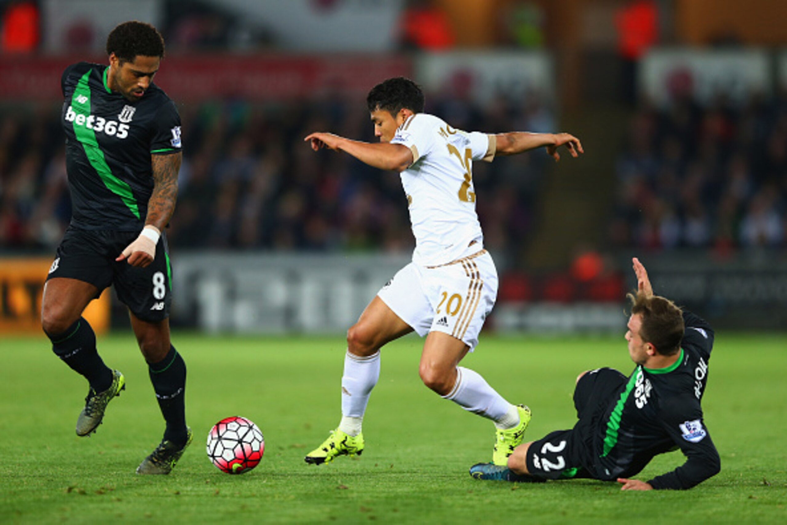 SWANSEA, WALES - OCTOBER 19:  Jefferson Montero of Swansea City takes on Glen Johnson (8) and Xherdan Shaqiri of Stoke City (22) during the Barclays Premier League match between Swansea City and Stoke City at Liberty Stadium on October 19, 2015 in Swansea