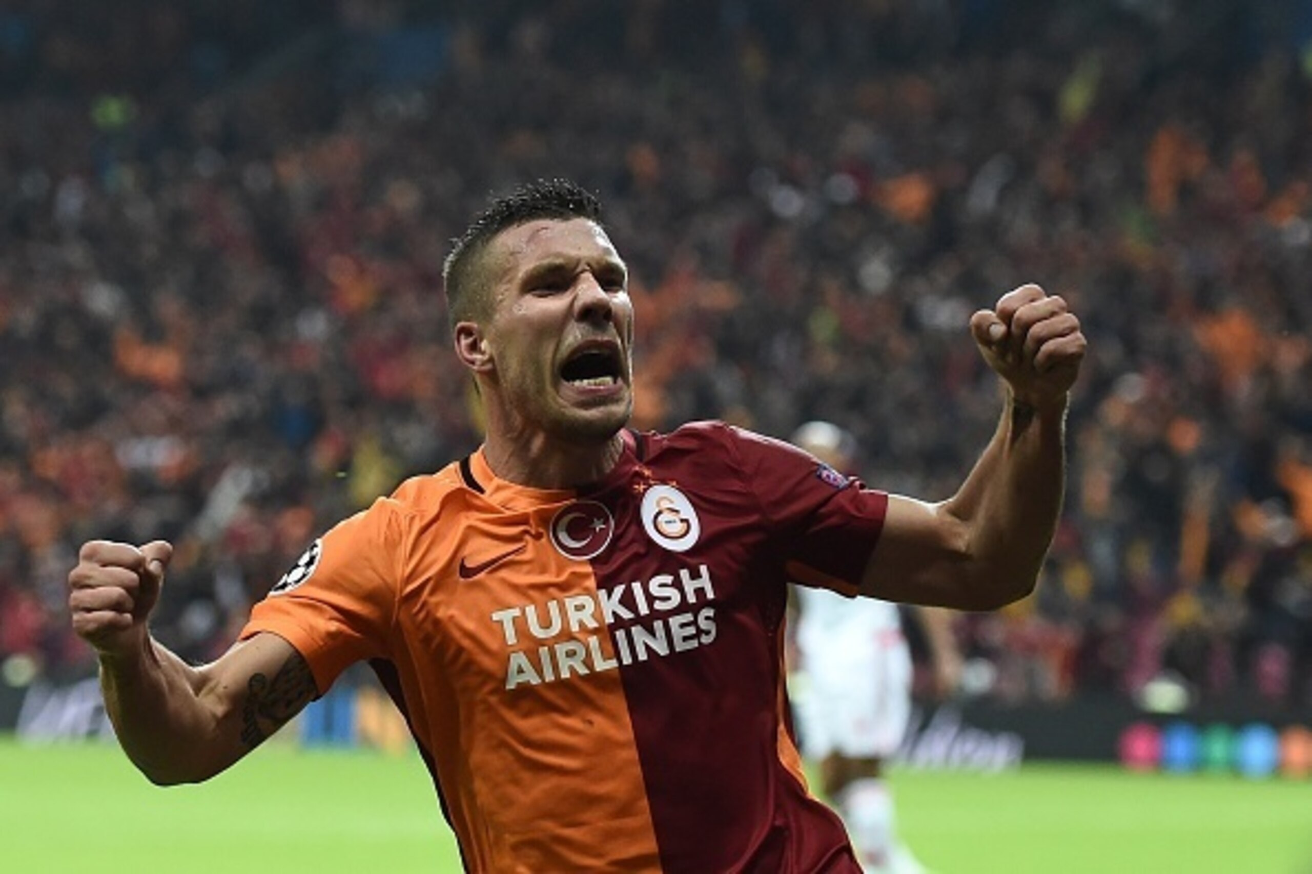 Galatasaray's German forward Lukas Podolski celebrates scoring during the UEFA Champions League football match between Galatasaray AS and SL Benfica at the Ali Sami Yen Spor Kompleks stadium in Istanbul on October 21, 2015. AFP PHOTO / OZAN KOSE        (P