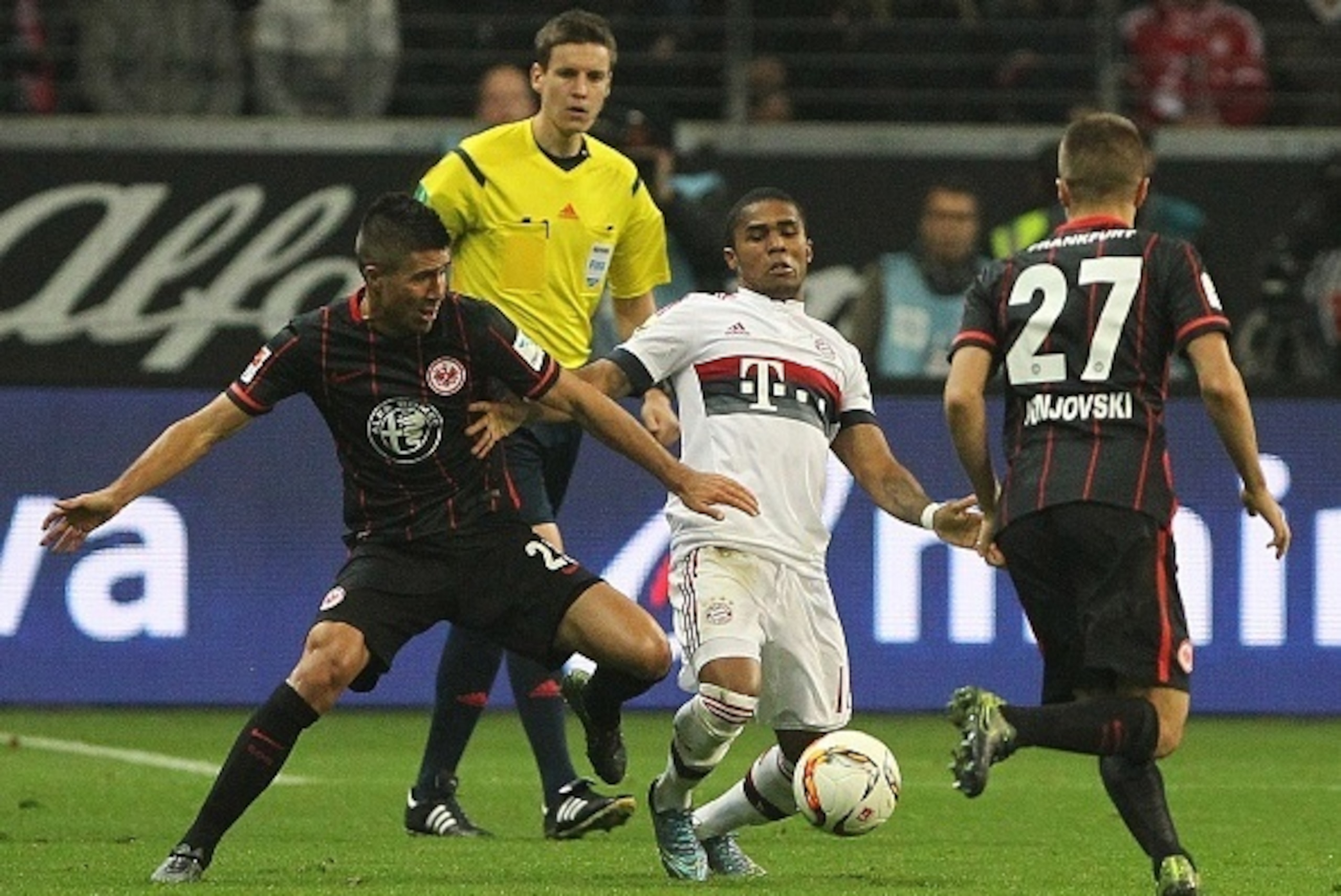 Frankfurt's Serbian midfielder Slobodan Medojevic (L) and Frankfurt's Serbian defender Aleksandar Ignjovski (R) vie for the ball with Bayern Munich's Brazilian midfielder Douglas Costa (C) during the German first division Bundesliga football match Eintrac