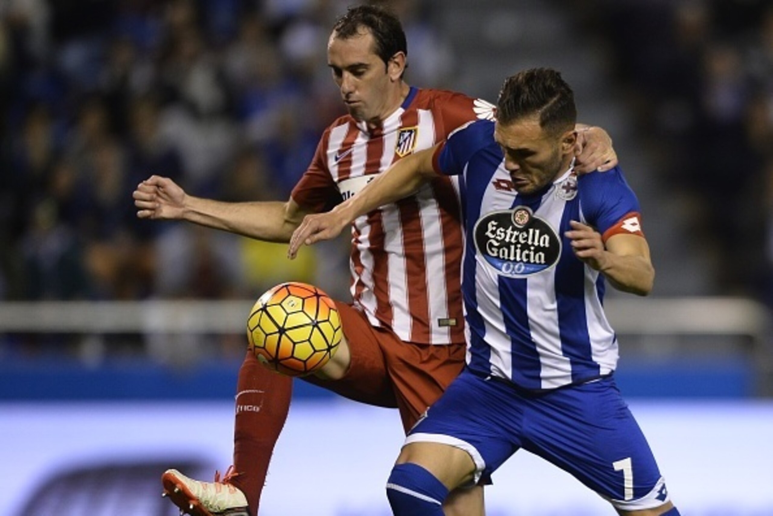 Deportivo La Coruna's midfielder Lucas Perez  (R) vies with Atletico Madrid's Uruguayan defender Diego Godin  during the Spanish league football match RC Deportivo La Coruna vs Club Atletico de Madrid at the Municipal de Riazor stadium in La Coruna on Oct