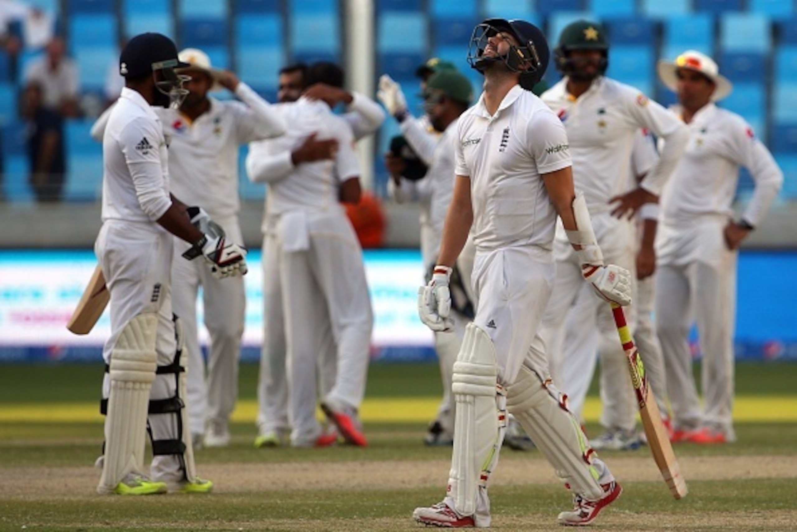 England's Mark Wood (C) reacts as he leaves the green after he was dismissed during the fifth and last day of the second Test cricket match between Pakistan and England in the Gulf emirate of Dubai on October 26, 2015. AFP PHOTO / MARWAN NAAMANI        (P