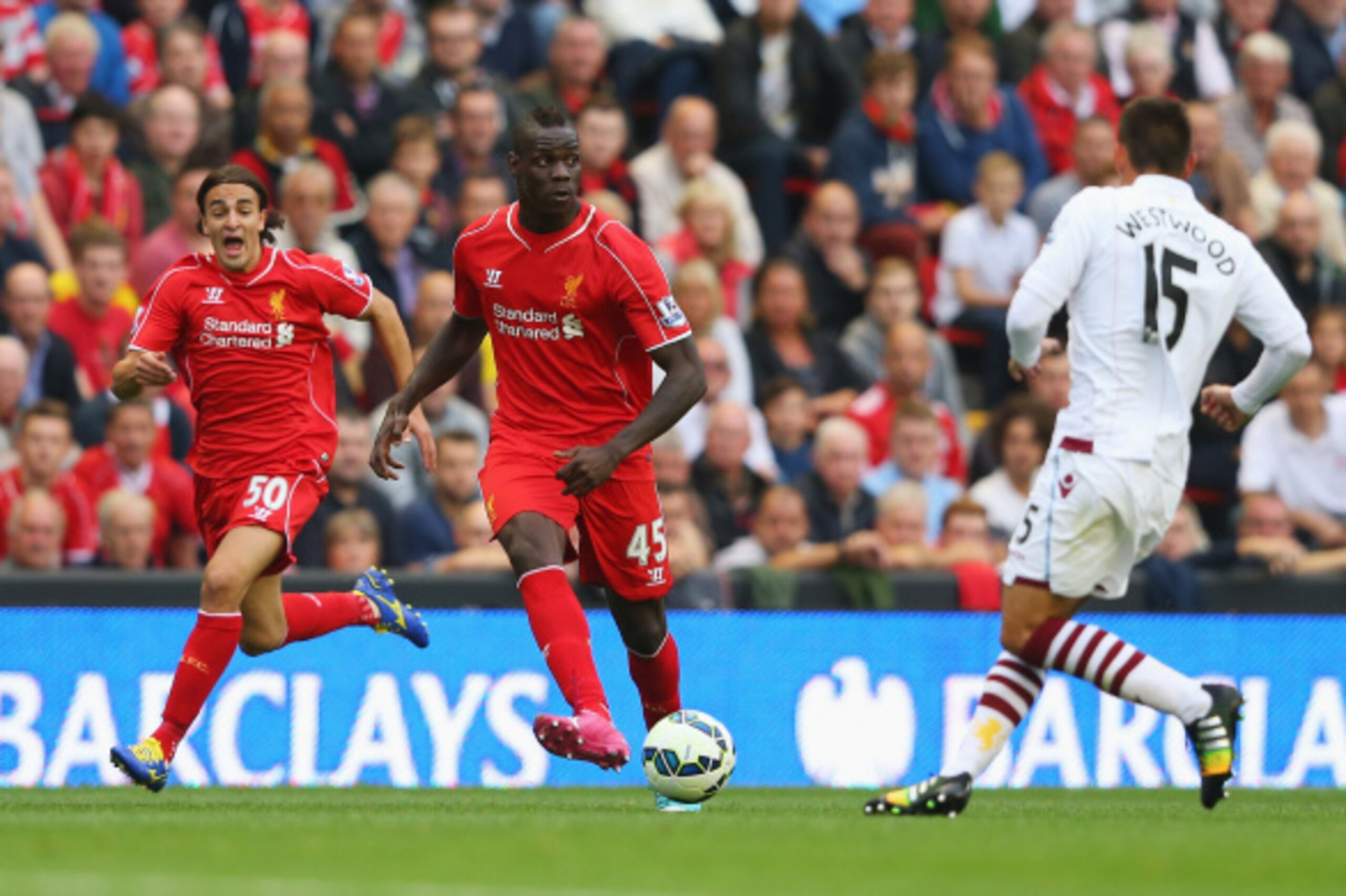 LIVERPOOL, ENGLAND - SEPTEMBER 13:  Mario Balotelli of Liverpool passes with Lazar Markovic of Liverpool on the overlap during the Barclays Premier League match between Liverpool and Aston Villa at Anfield on September 13, 2014 in Liverpool, England.  (Ph
