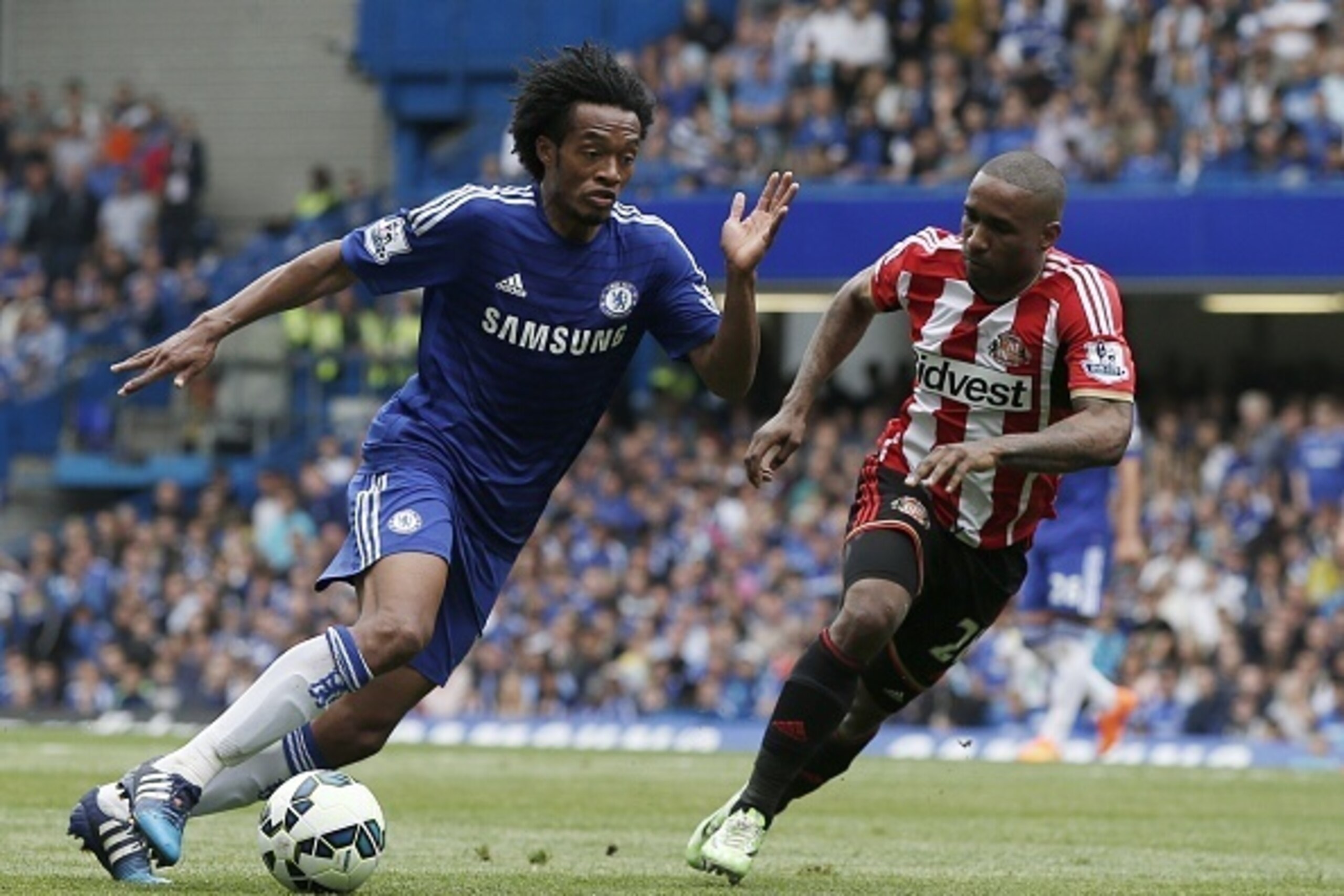 Chelsea's Colombian midfielder Juan Cuadrado (L) vies with Sunderland's English striker Jermain Defoe during the English Premier League football match between Chelsea and Sunderland at Stamford Bridge in London on May 24, 2015. 
AFP PHOTO / ADRIAN DENNIS
