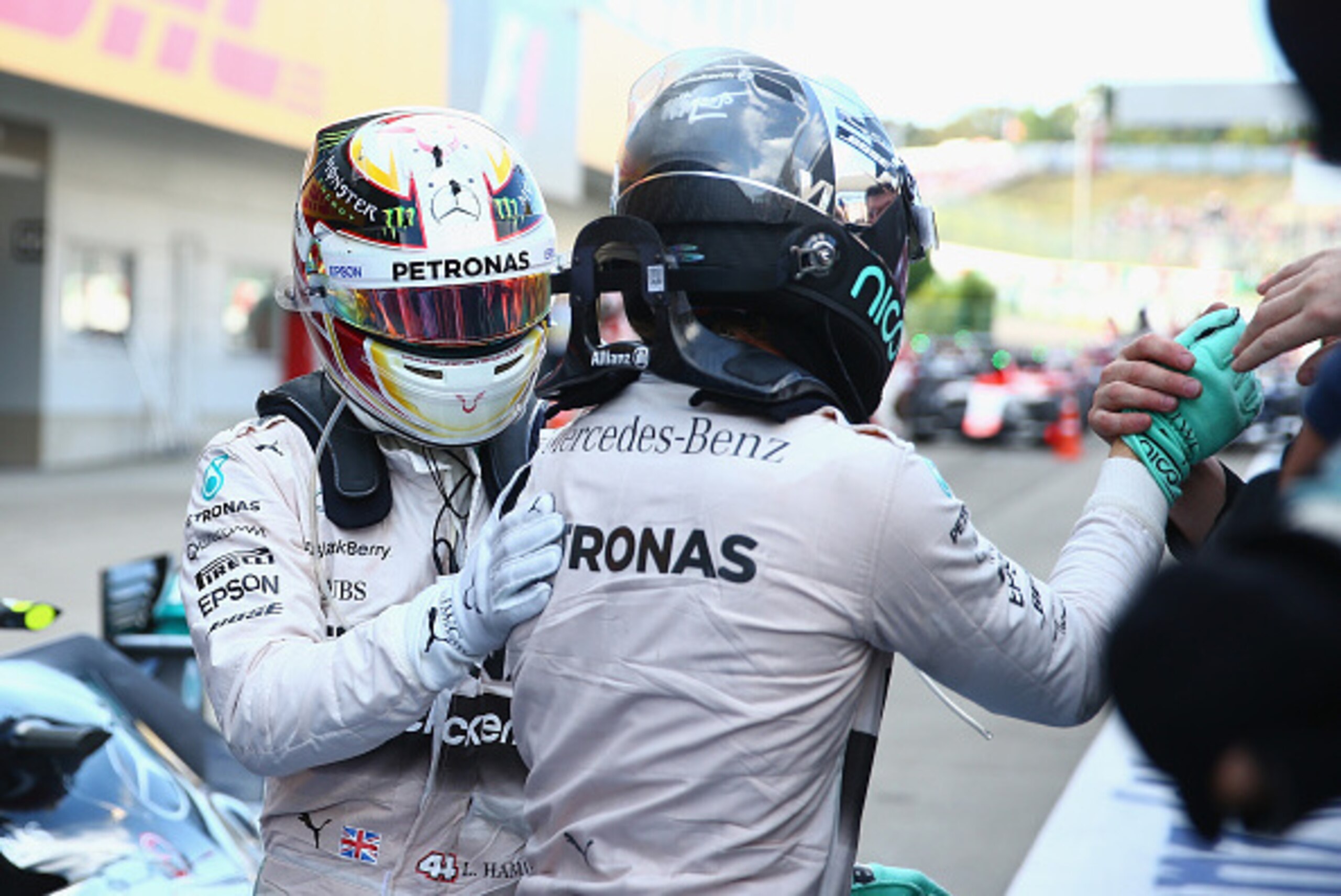 SUZUKA, JAPAN - SEPTEMBER 27:  Lewis Hamilton of Great Britain and Mercedes GP pats Nico Rosberg of Germany and Mercedes GP on the back as he celebrates in Parc Ferme after winning the Formula One Grand Prix of Japan at Suzuka Circuit on September 27, 201
