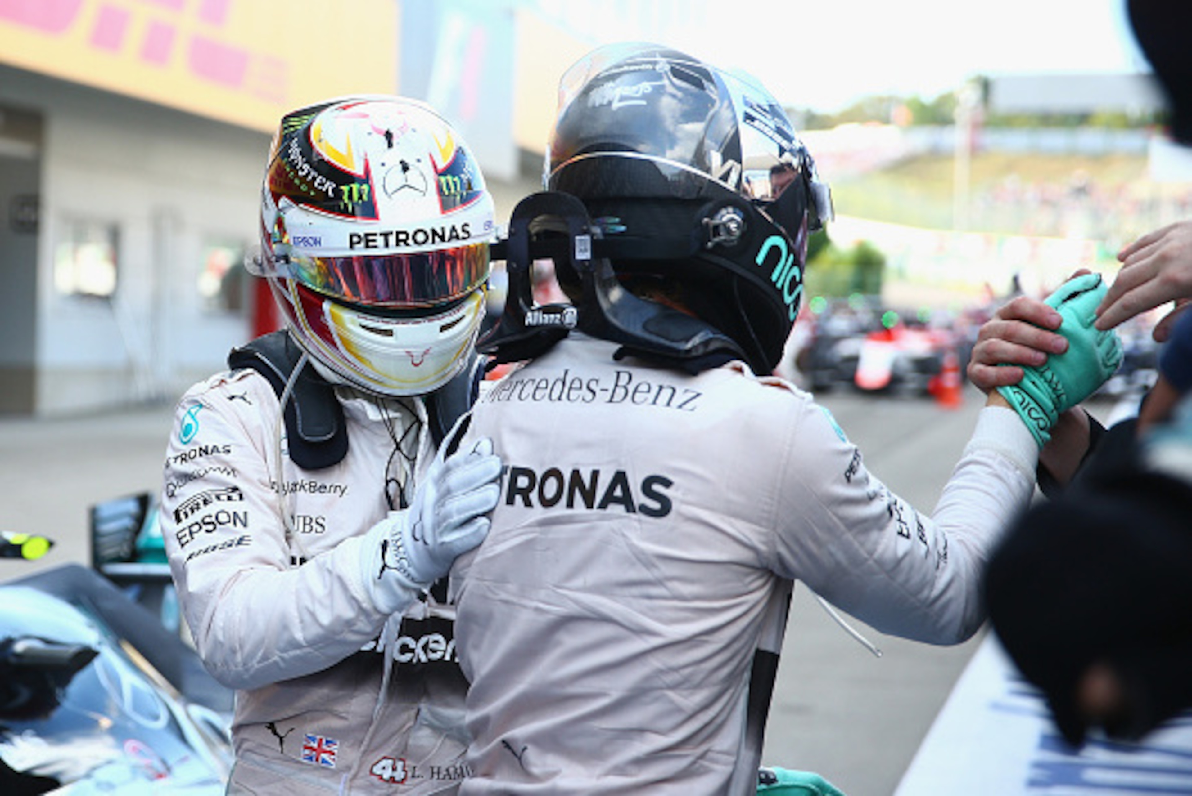SUZUKA, JAPAN - SEPTEMBER 27:  Lewis Hamilton of Great Britain and Mercedes GP pats Nico Rosberg of Germany and Mercedes GP on the back as he celebrates in Parc Ferme after winning the Formula One Grand Prix of Japan at Suzuka Circuit on September 27, 201