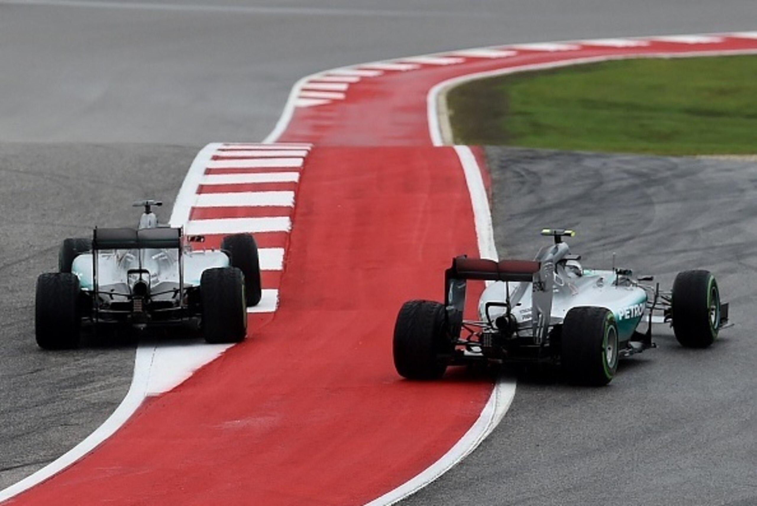 Mercedes AMG Petronas driver Lewis Hamilton of Britain (L) forces teammate Nico Rosberg of Germany (R) wide on the first corner on the first lap of the United States Formula One Grand Prix at the Circuit of The Americas in Austin, Texas on October 25, 201