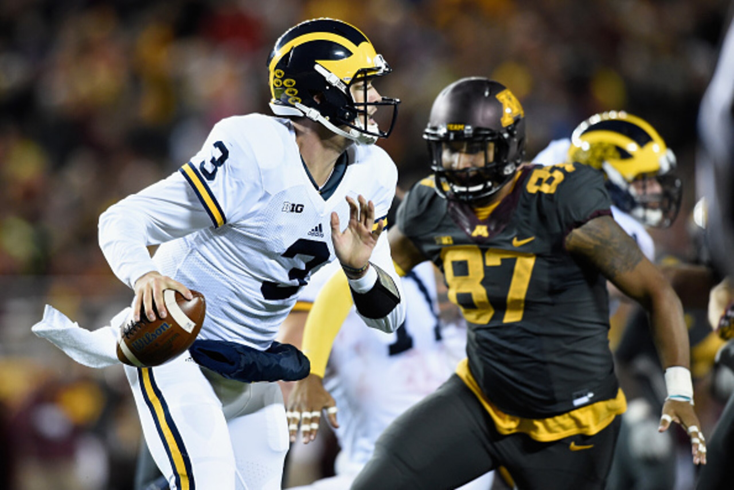 MINNEAPOLIS, MN - OCTOBER 31: Wilton Speight #3 of the Michigan Wolverines scrambles with the ball with pressure from Gaelin Elmore #87 of the Minnesota Golden Gophers during the fourth quarter of the game on October 31, 2015 at TCF Bank Stadium in Minnea
