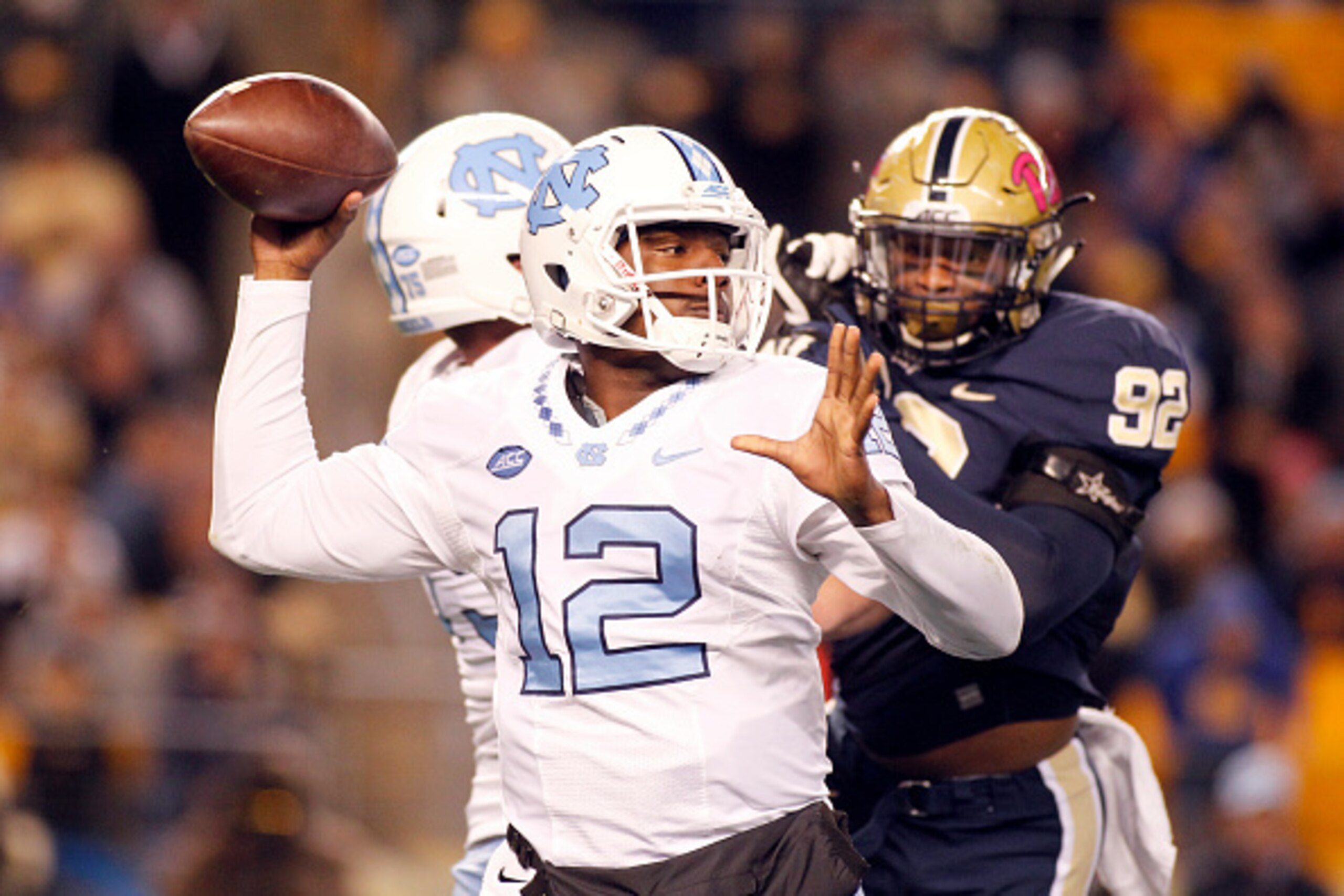 PITTSBURGH, PA - OCTOBER 29:  Marquise Williams #12 of the North Carolina Tar Heels drops back to pass under pressure by Rori Blair #92 of the Pittsburgh Panthers in the first half during the game on October 29, 2015 at Heinz Field in Pittsburgh, Pennsylv