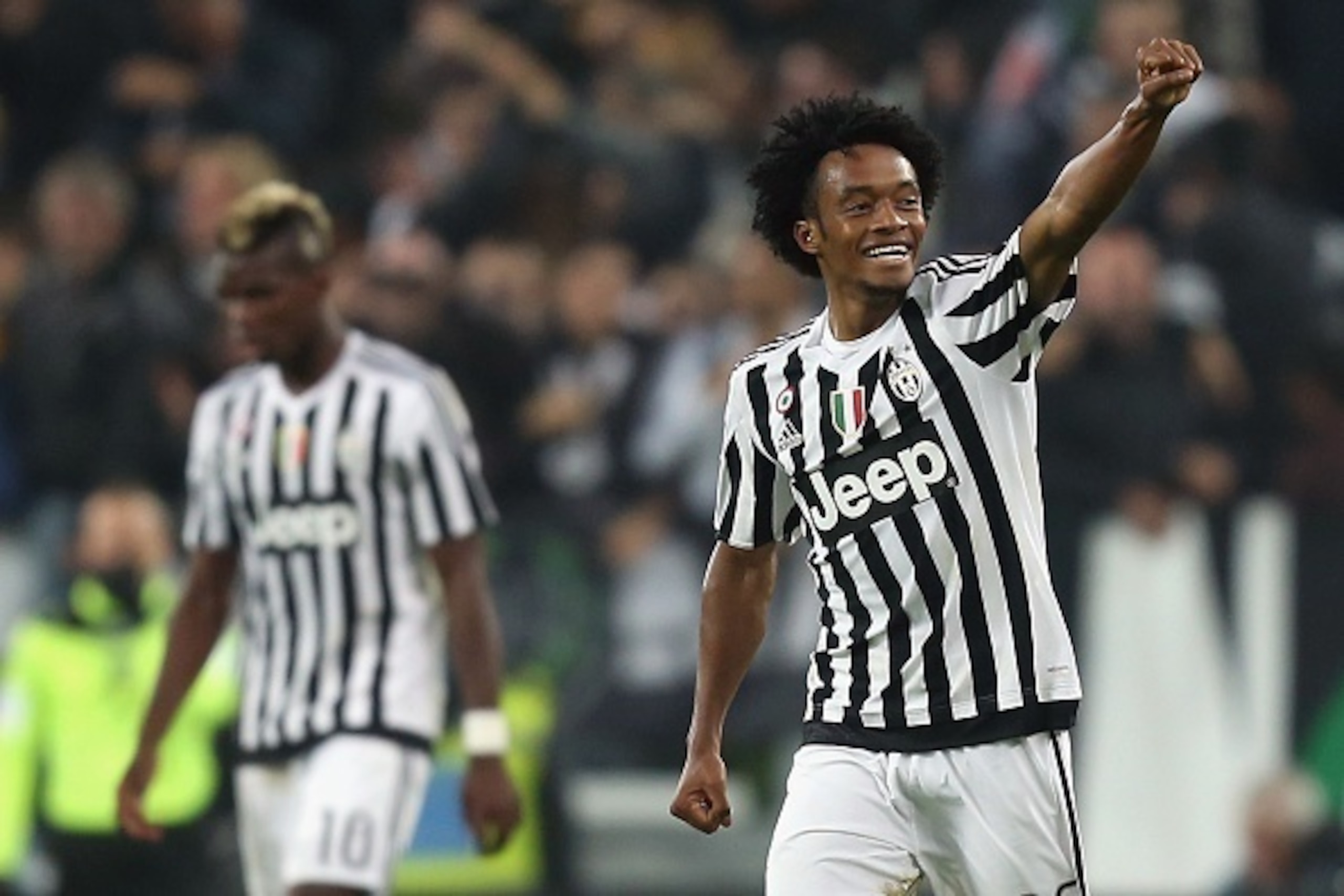 Juventus' midfielder Juan Cuadrado from Colombia (R) celebrates after scoring during the Italian Serie A  football match Juventus Vs Torino on October 31, 2015 at the Juventus Stadium in Turin.  AFP PHOTO / MARCO BERTORELLO        (Photo credit should rea