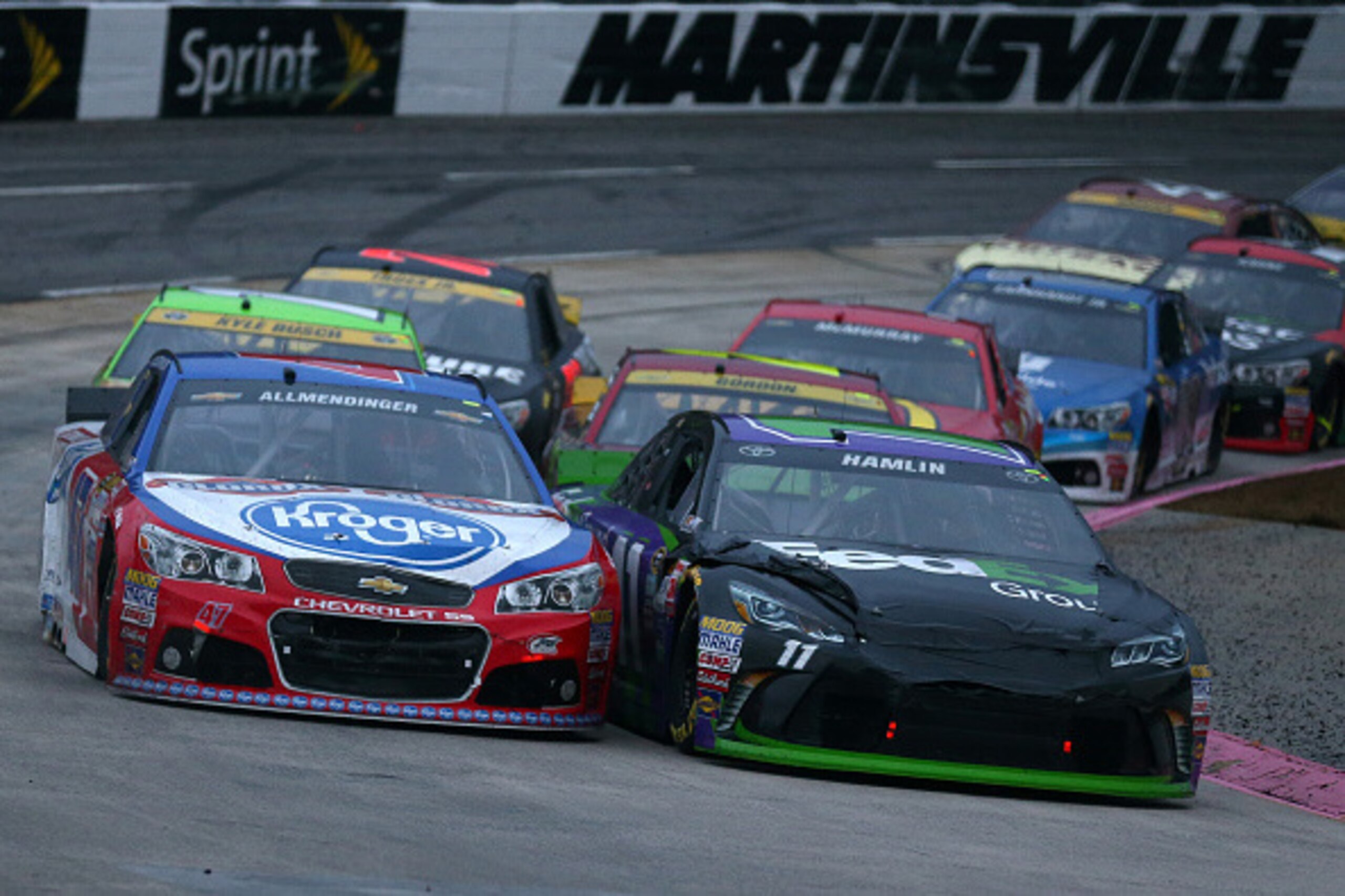 MARTINSVILLE, VA - NOVEMBER 01:  AJ Allmendinger, driver of the #47 Kroger/Clorox Chevrolet, and Denny Hamlin, driver of the #11 FedEx Ground Toyota, lead a pack of cars during the NASCAR Sprint Cup Series Goody's Headache Relief Shot 500 at Martinsville 