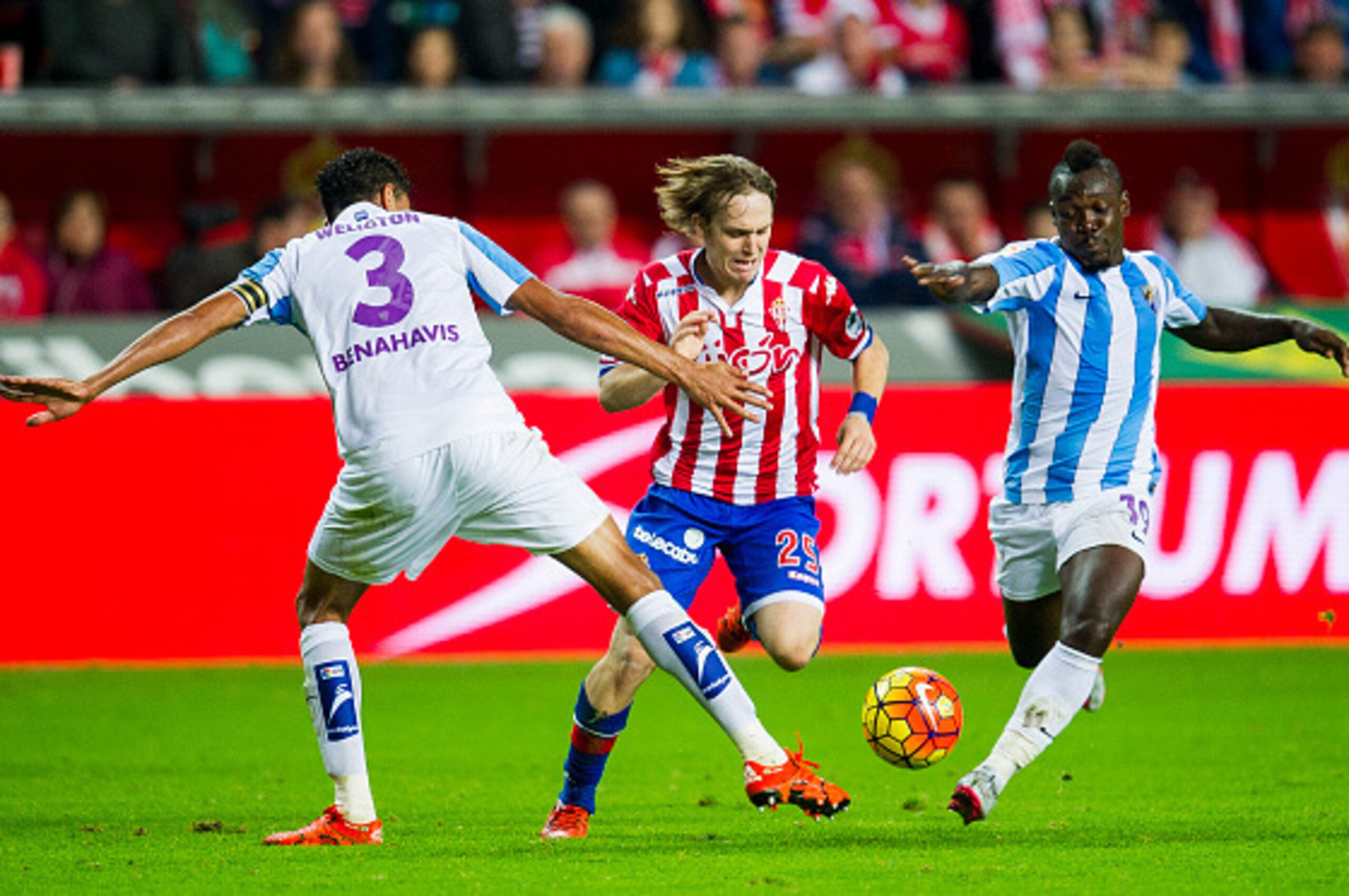 GIJON, SPAIN - NOVEMBER 01: Halilovic (C) of Real Sporting de Gijon duels for the ball with Weligton and Arthur Boka (R) of Malaga CF during the La Liga match between Real Sporting de Gijon and Malaga CF at Estadio El Molinon on November 1, 2015 in Gijon,