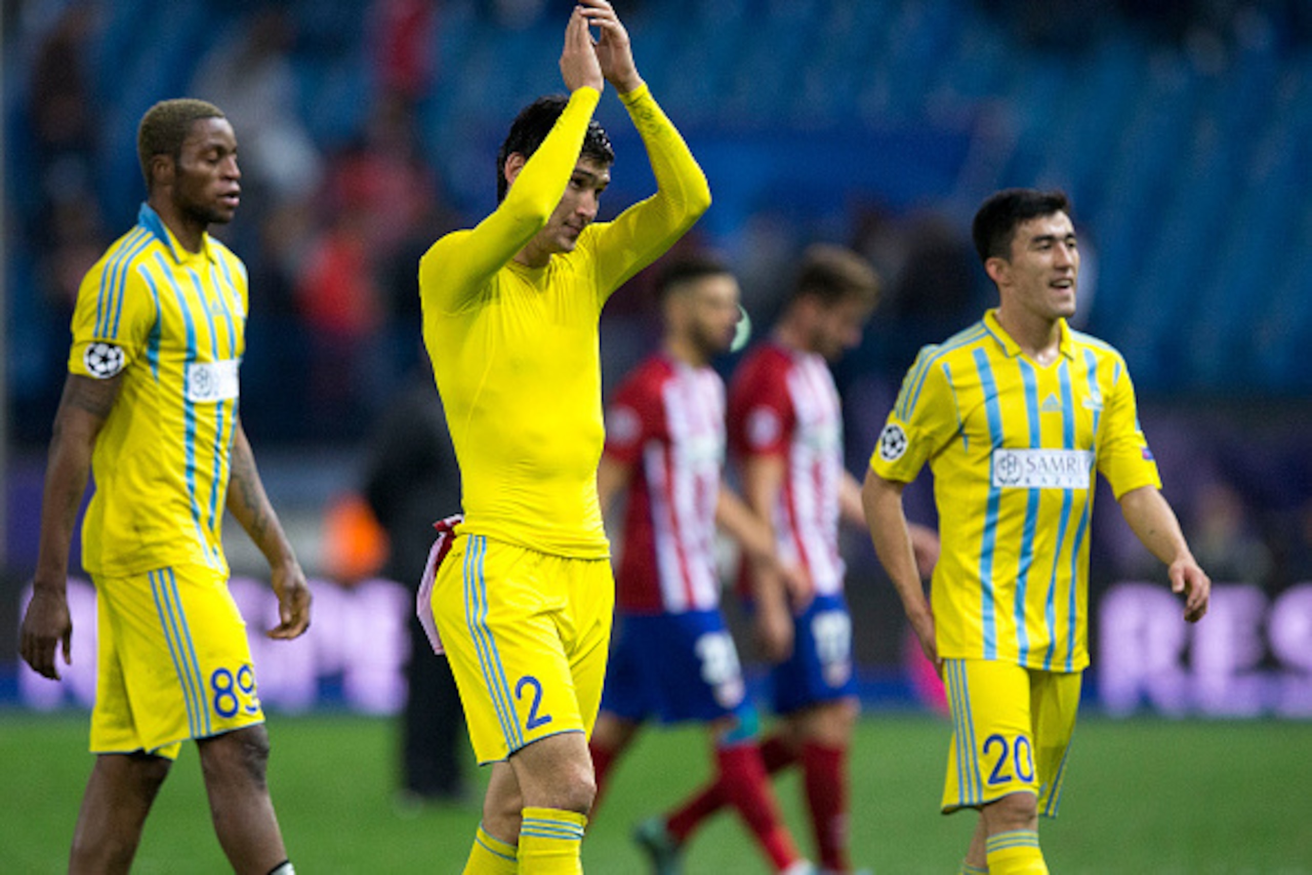 MADRID, SPAIN - OCTOBER 21: Yeldos Akhmetov (2ndL) of FC Astana claps to his fans surrounded by Junior Kabananga (L) and Zhakyp Kozhamberdy (R) after loosing the UEFA Champions League Group C match between Club Atletico de Madrid and FC Astana at Vicente 