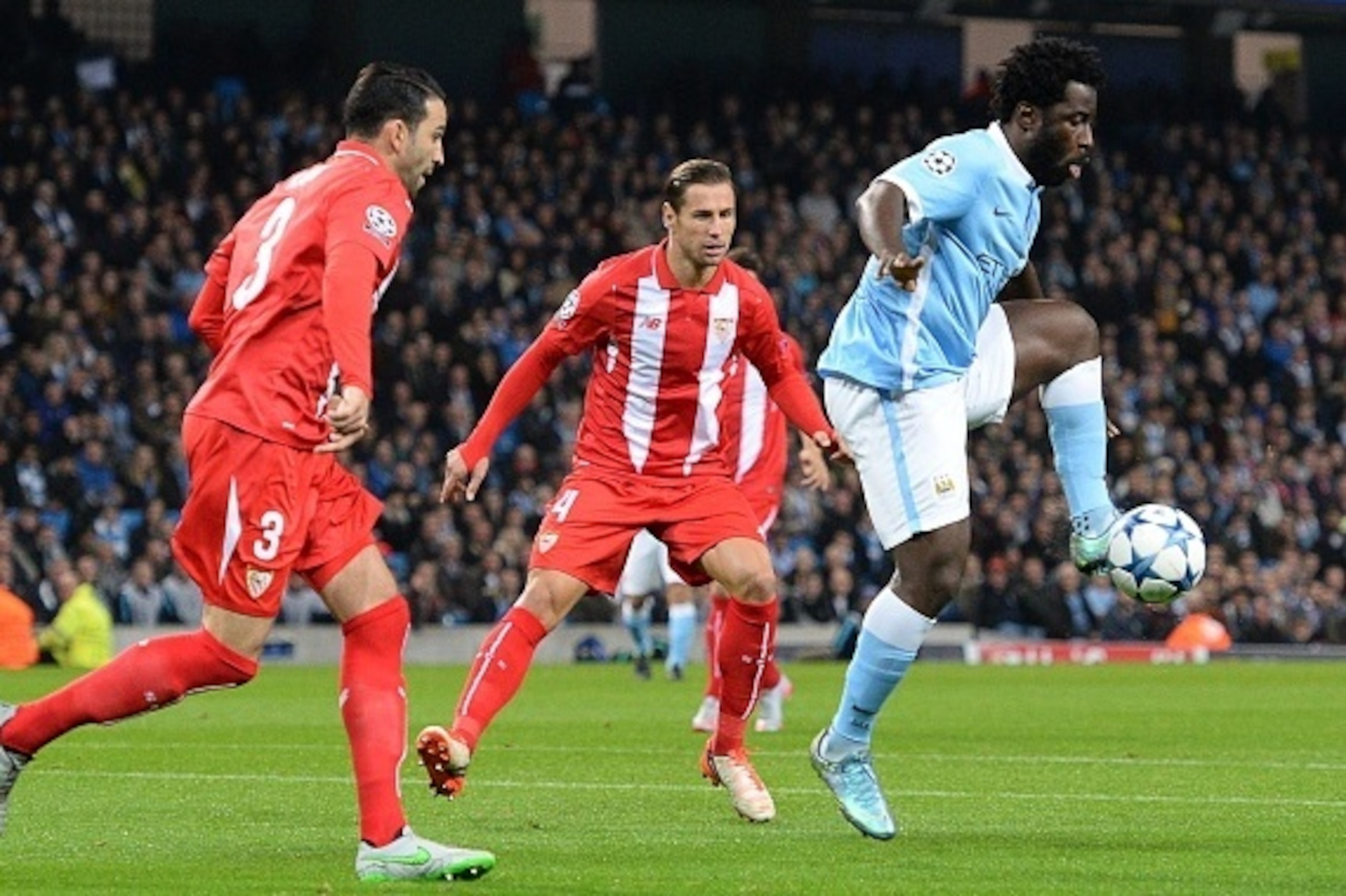 Manchester City's Ivorian striker Wilfried Bony (R) controls the ball next to Sevilla's French defender Adil Rami (L) and Sevilla's Polish midfielder Grzegorz Krychowiak (C) during a UEFA Champions league Group D football match between Manchester City and