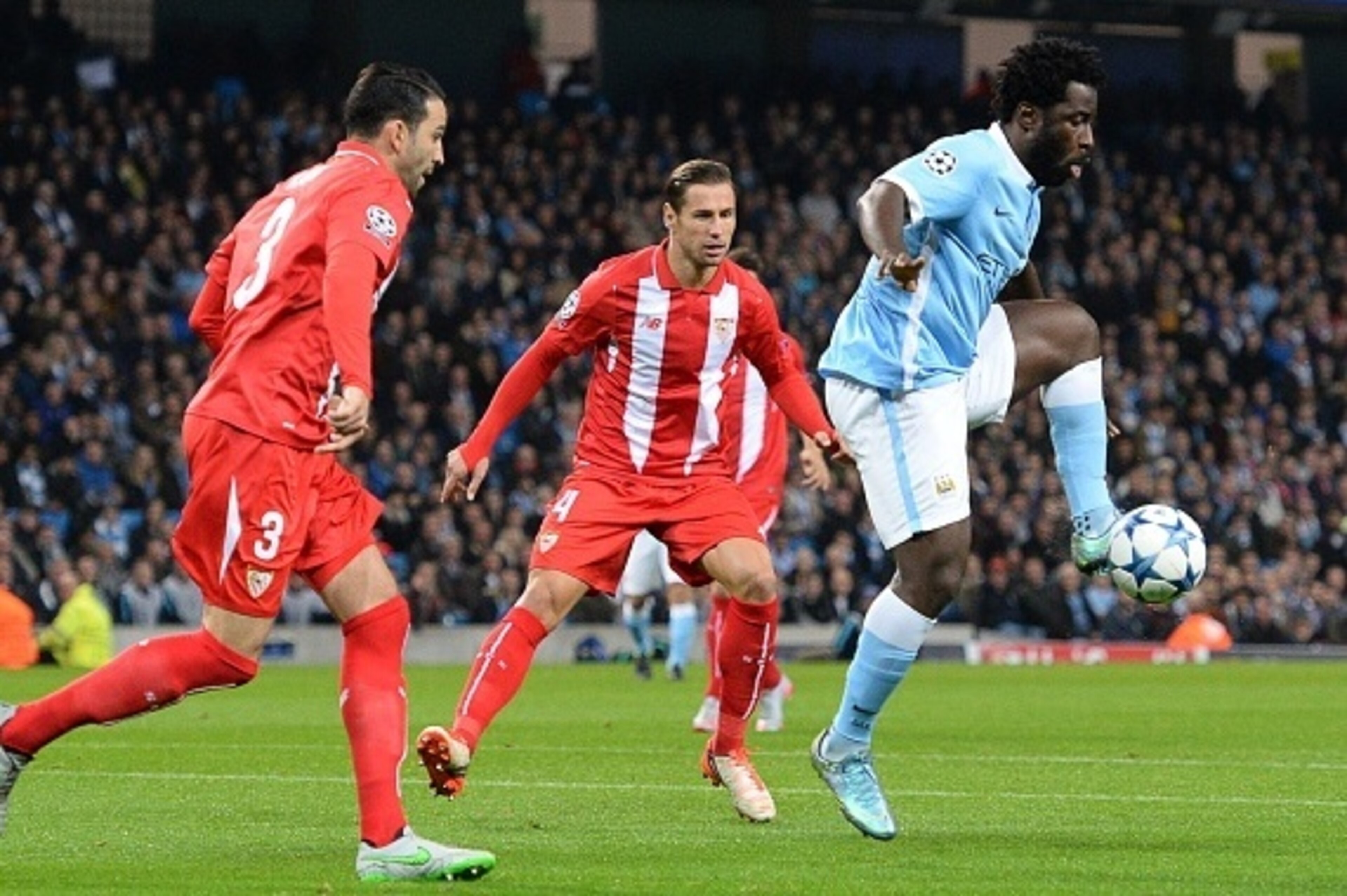 Manchester City's Ivorian striker Wilfried Bony (R) controls the ball next to Sevilla's French defender Adil Rami (L) and Sevilla's Polish midfielder Grzegorz Krychowiak (C) during a UEFA Champions league Group D football match between Manchester City and